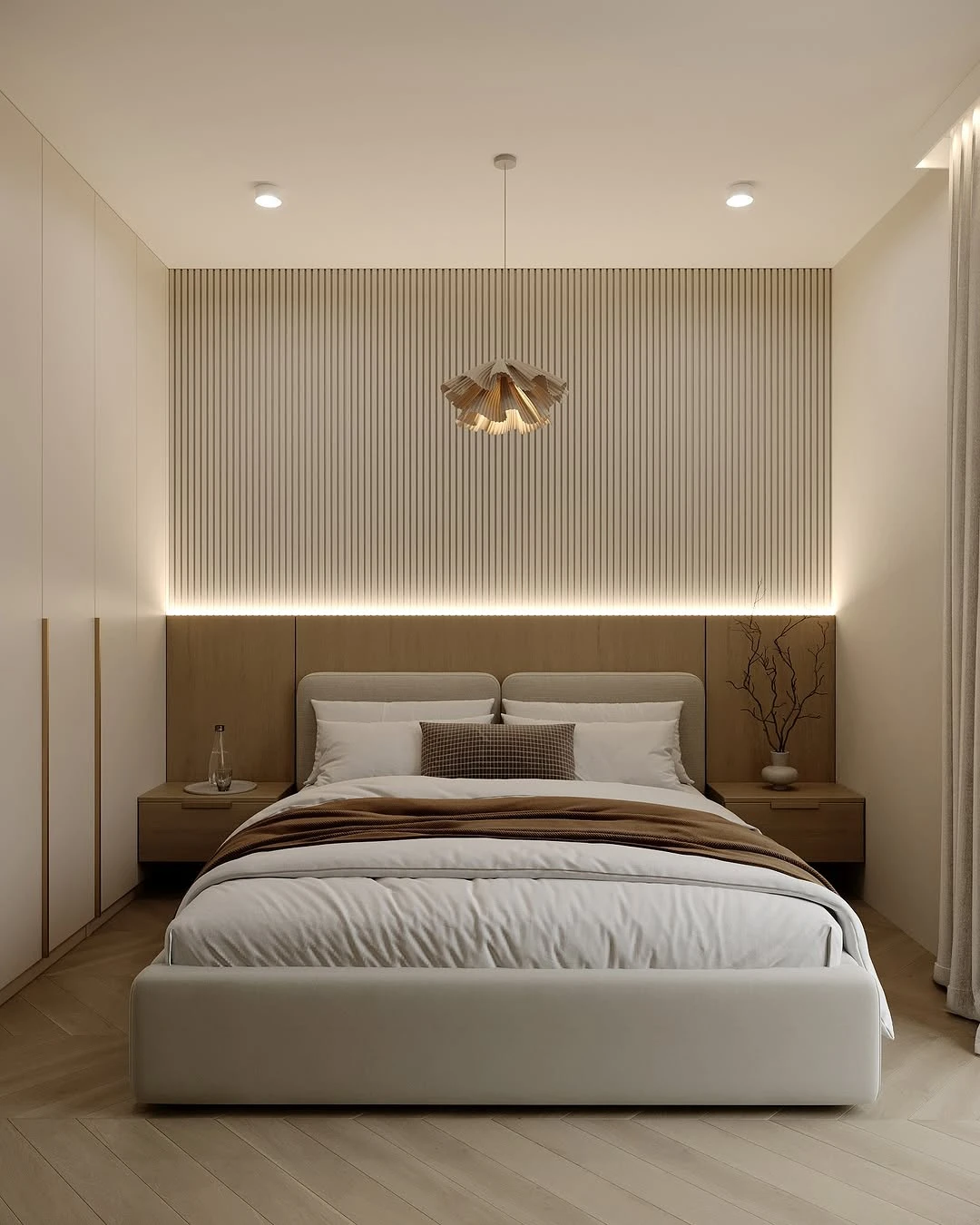 Elegant small bedroom with beige bed, vertical wood panels, pendant light, nightstands, and sheer curtains.