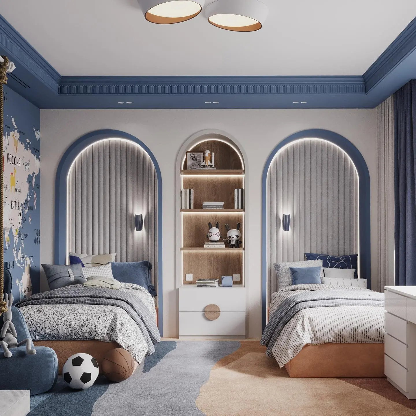 A shared children's bedroom featuring two identical single beds on either side of a central bookshelf unit. The beds are set within large arched recesses with vertical upholstered panels and integrated lighting. The room is decorated in a blue and white color scheme, with a world map mural on one wall.