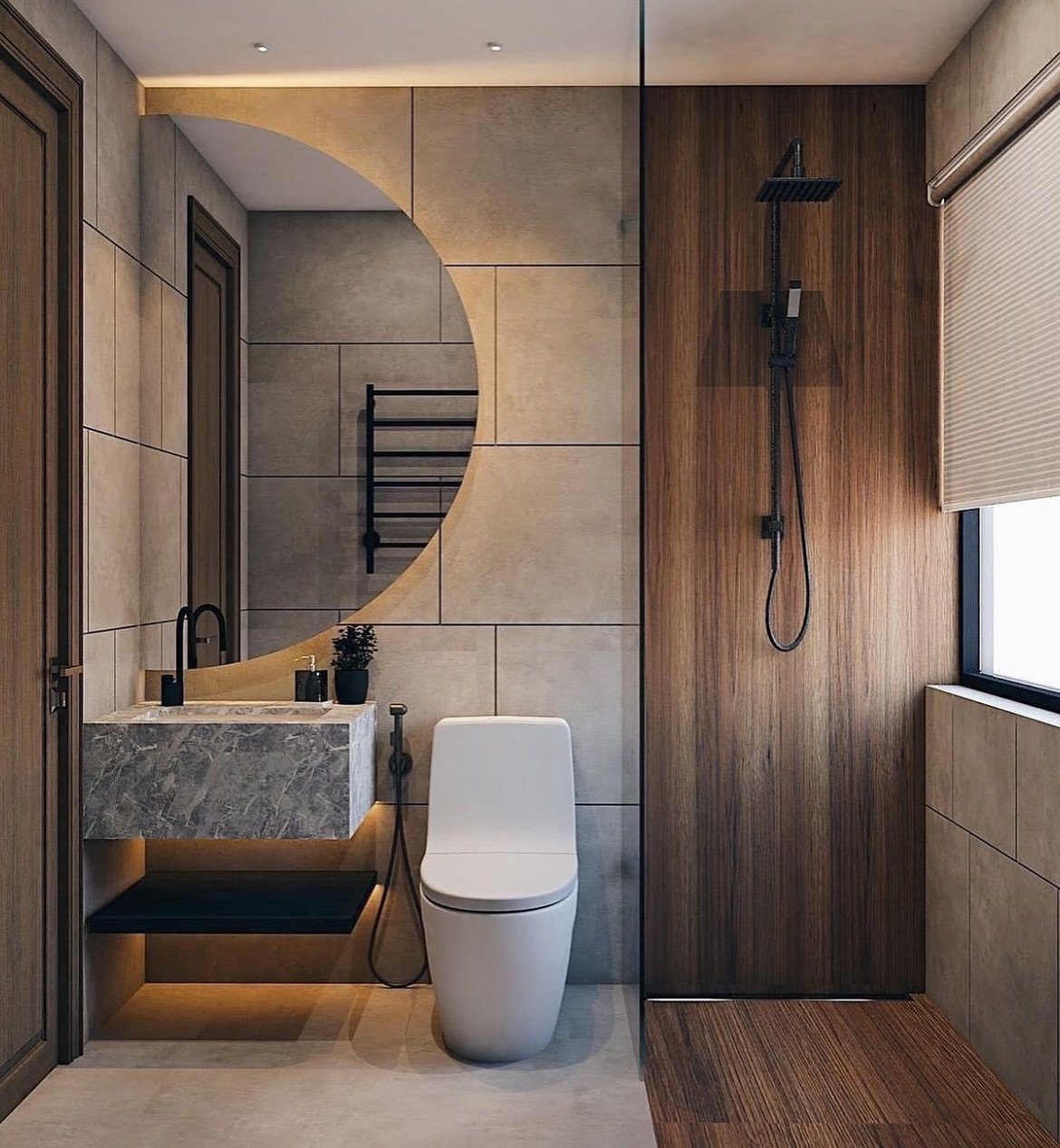 A modern, compact bathroom featuring a unique half-moon mirror with backlighting, a floating marble-look vanity, and a shower area with wood-look tile flooring and a dark wood-paneled wall.