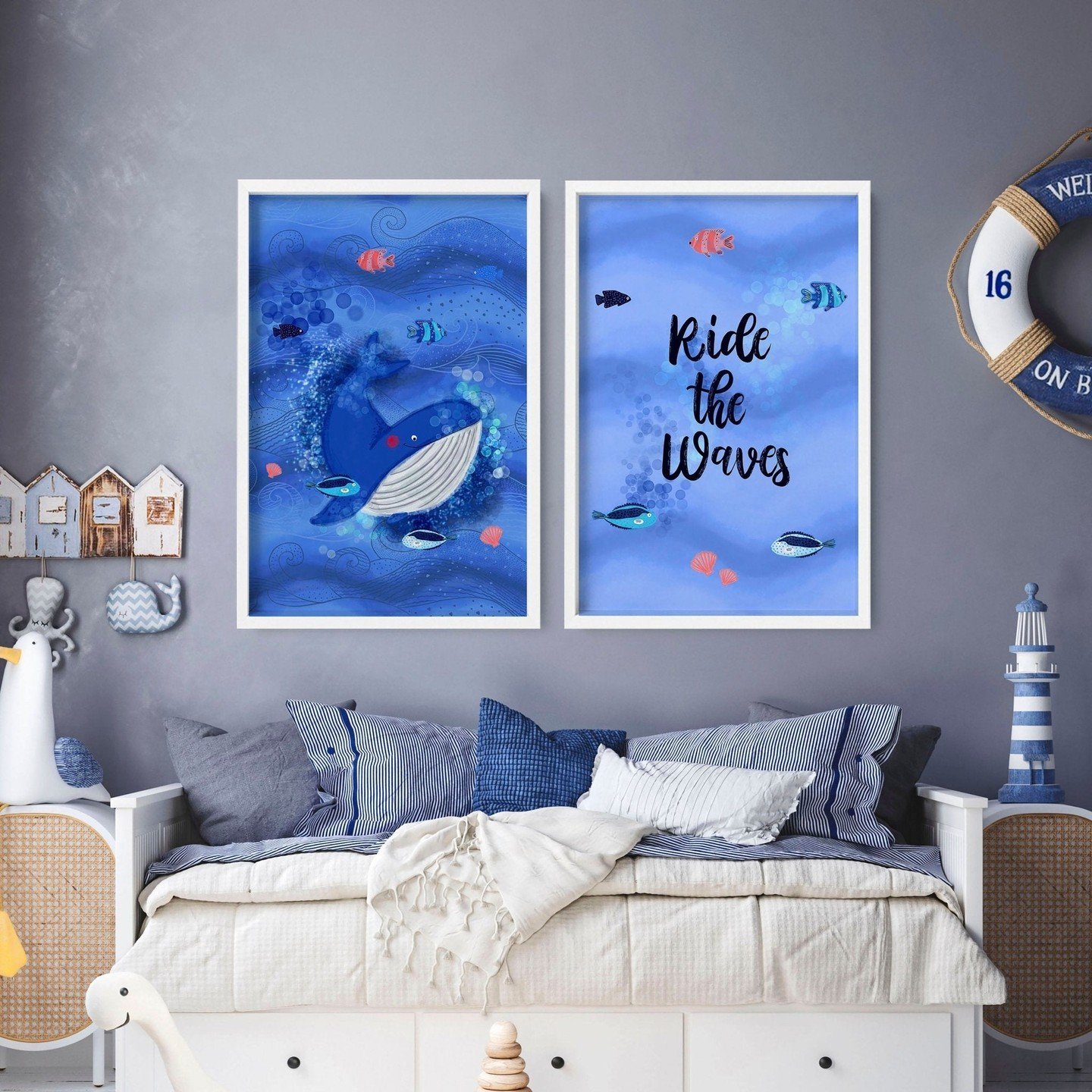 A nursery room with a daybed, two framed whale and fish art prints, and coastal decor against a dark gray wall.