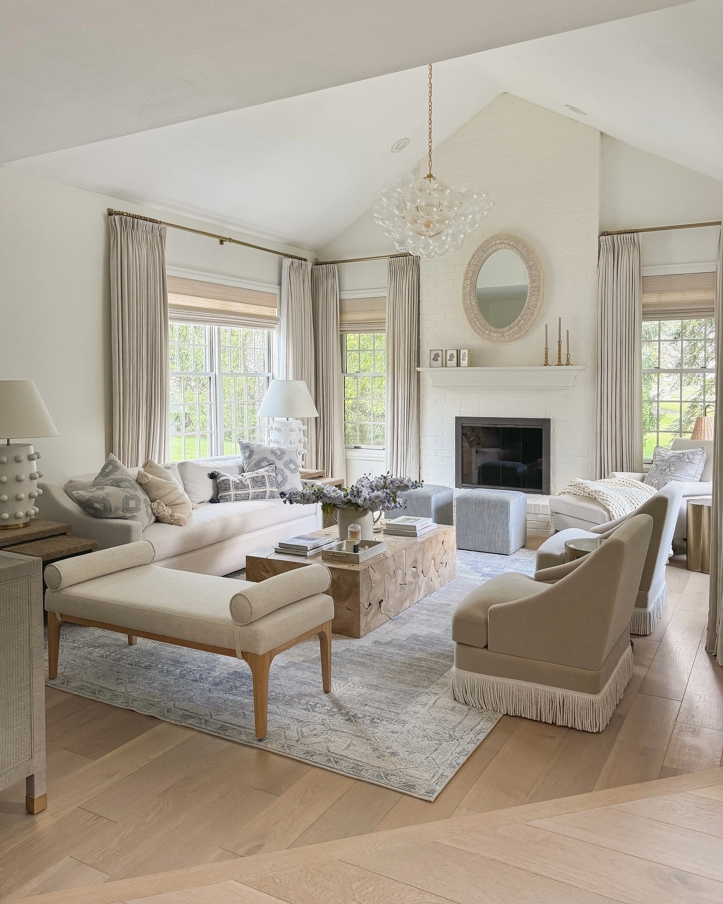 A light, vintage-style area rug with a subtle, faded gray and blue pattern on a light wood herringbone floor.
