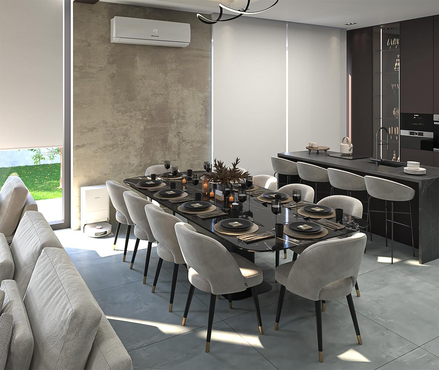 A luxurious and dramatic open-concept dining and kitchen area. A long black marble dining table is set with dark plates and candles, surrounded by ten elegant cream-colored chairs. The kitchen island is made of matching dark marble, with three grey bar stools.