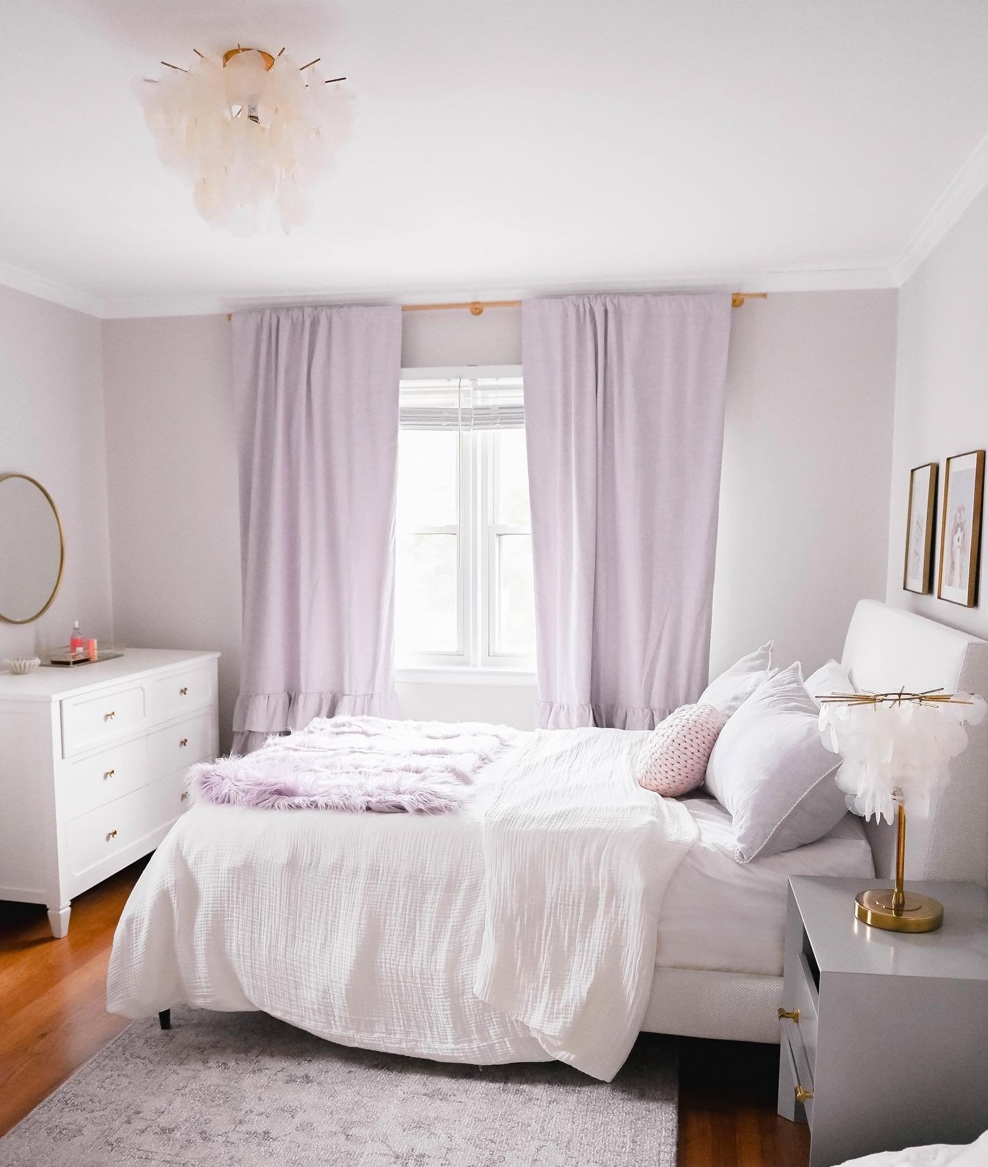 A bright and airy teen girl's bedroom with a soft lilac and white color scheme, featuring a plush bed and elegant, modern furnishings.