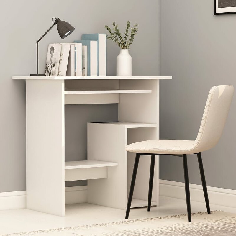 A compact, minimalist white study desk with stepped open shelving, a black desk lamp, and a modern chair with a patterned seat.