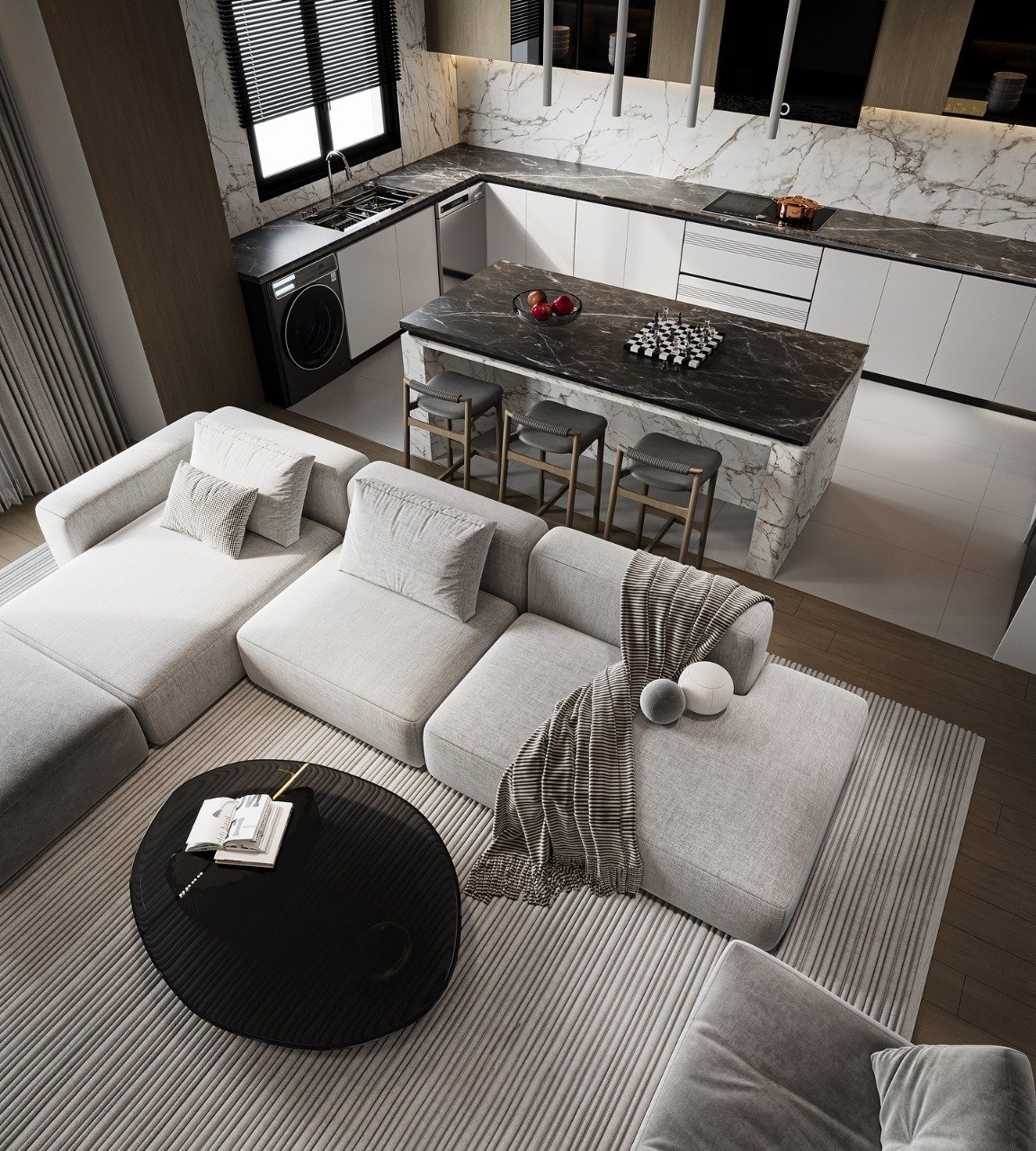 A luxurious, high-angle view of a modern open-concept kitchen and living room. The living area features a large light grey sectional sofa and a round black coffee table on a striped rug. The kitchen has a stunning black marble island with three stools and white marble backsplash and countertops.