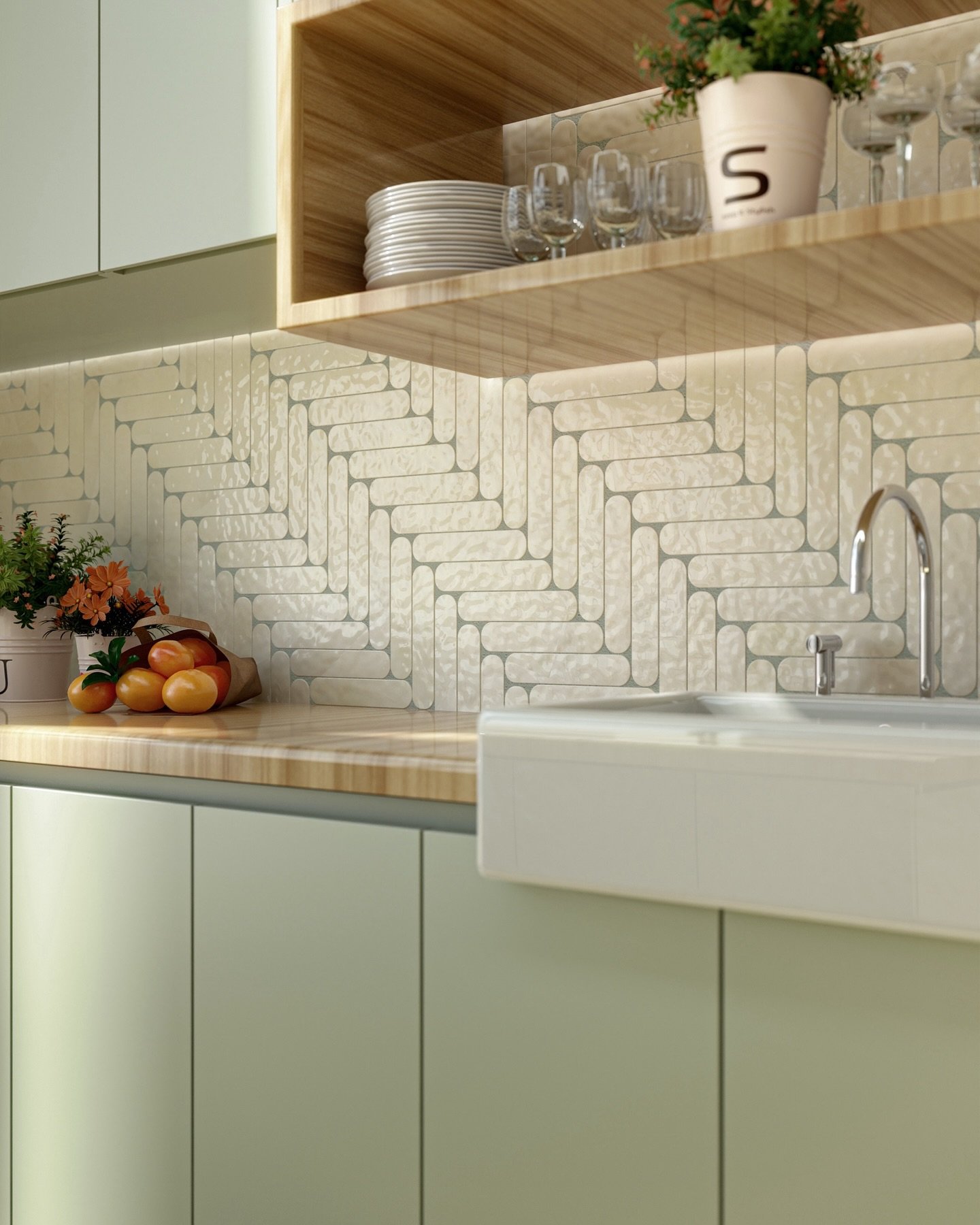 A close-up of a kitchen backsplash made of off-white, rounded-edge picket tiles arranged in a diagonal herringbone pattern, with mint green cabinets and light wood countertops.