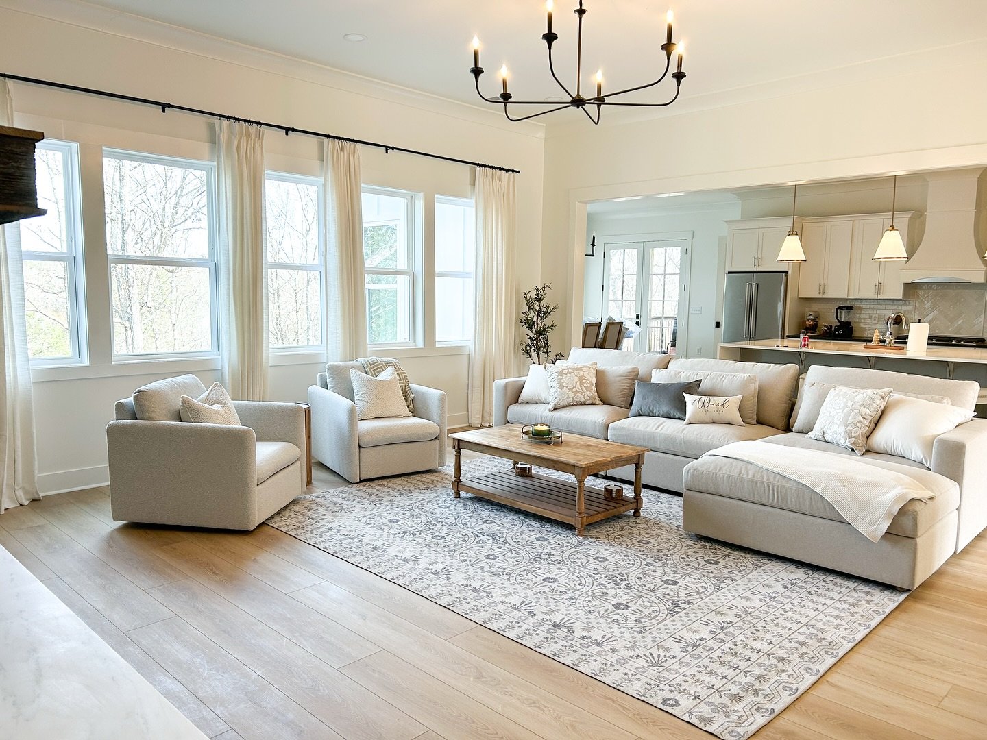 A light gray or off-white area rug with a subtle linear striped pattern on a light wood floor in a modern living room.
