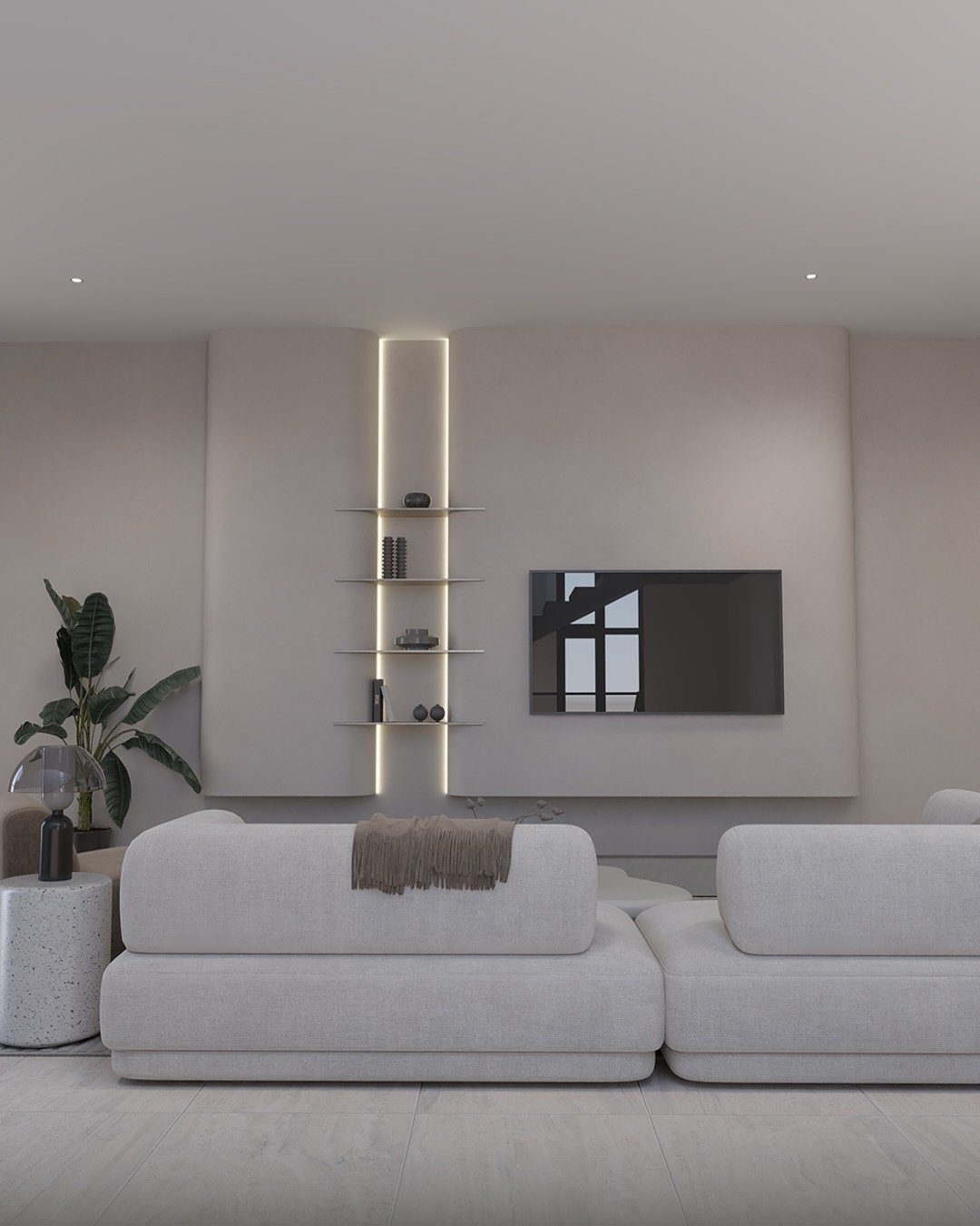  A minimalist living room with a large, light gray modular sofa, a TV mounted on a soft beige wall, and a vertical recessed light strip illuminating floating shelves.