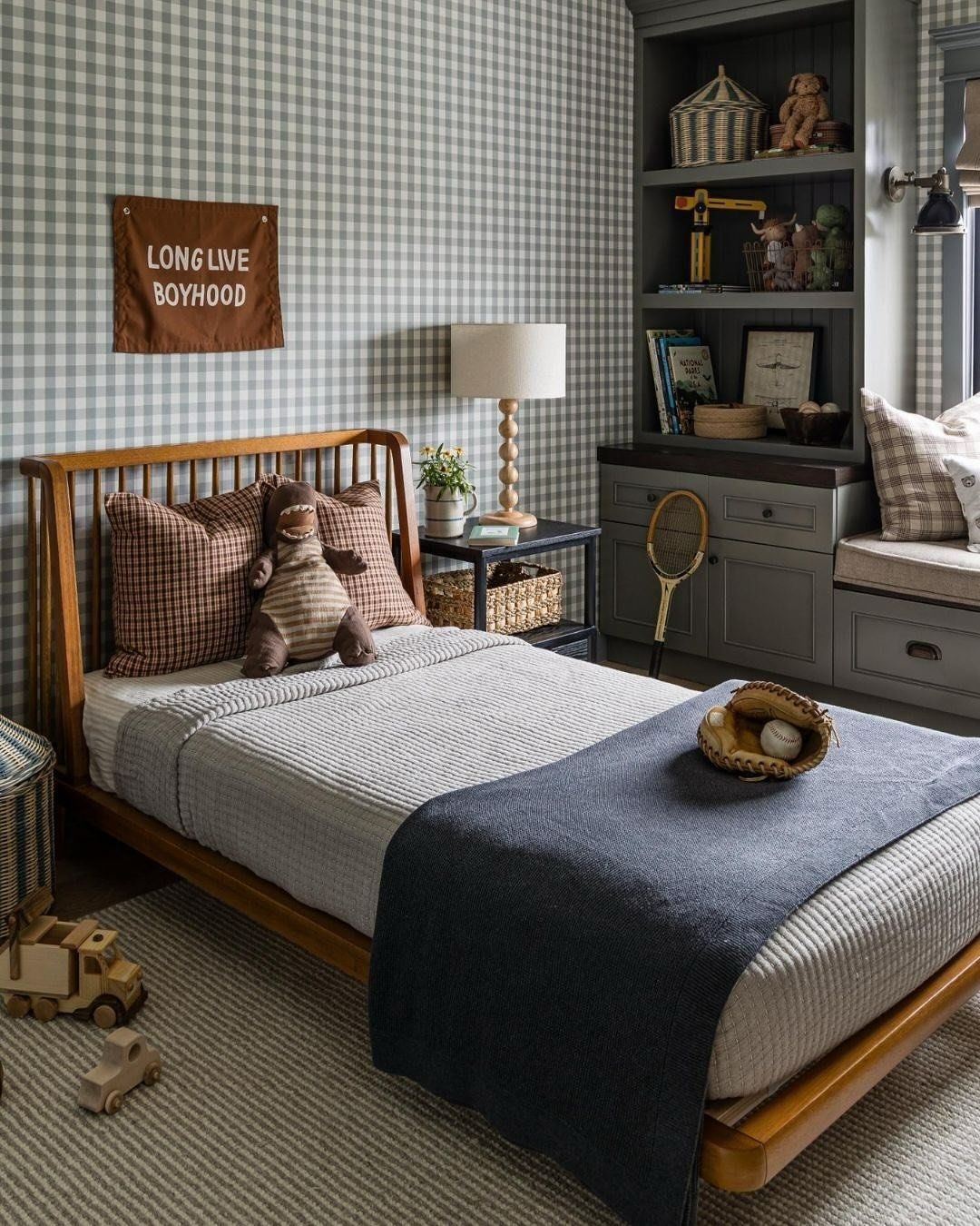 A cozy, vintage-inspired boy's bedroom with a wooden bed, checkered wallpaper, and sports memorabilia.