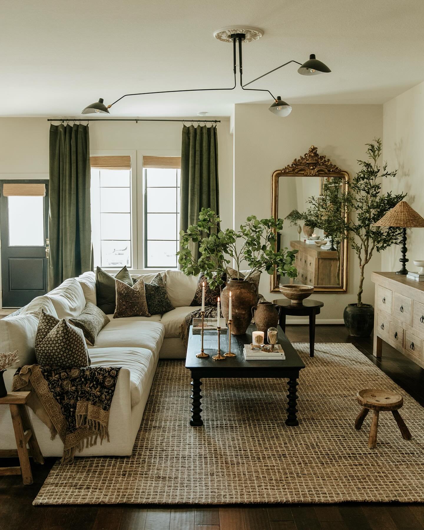 A large, textured, light-colored jute or sisal rug with a woven grid pattern on a dark wood floor in a living room.