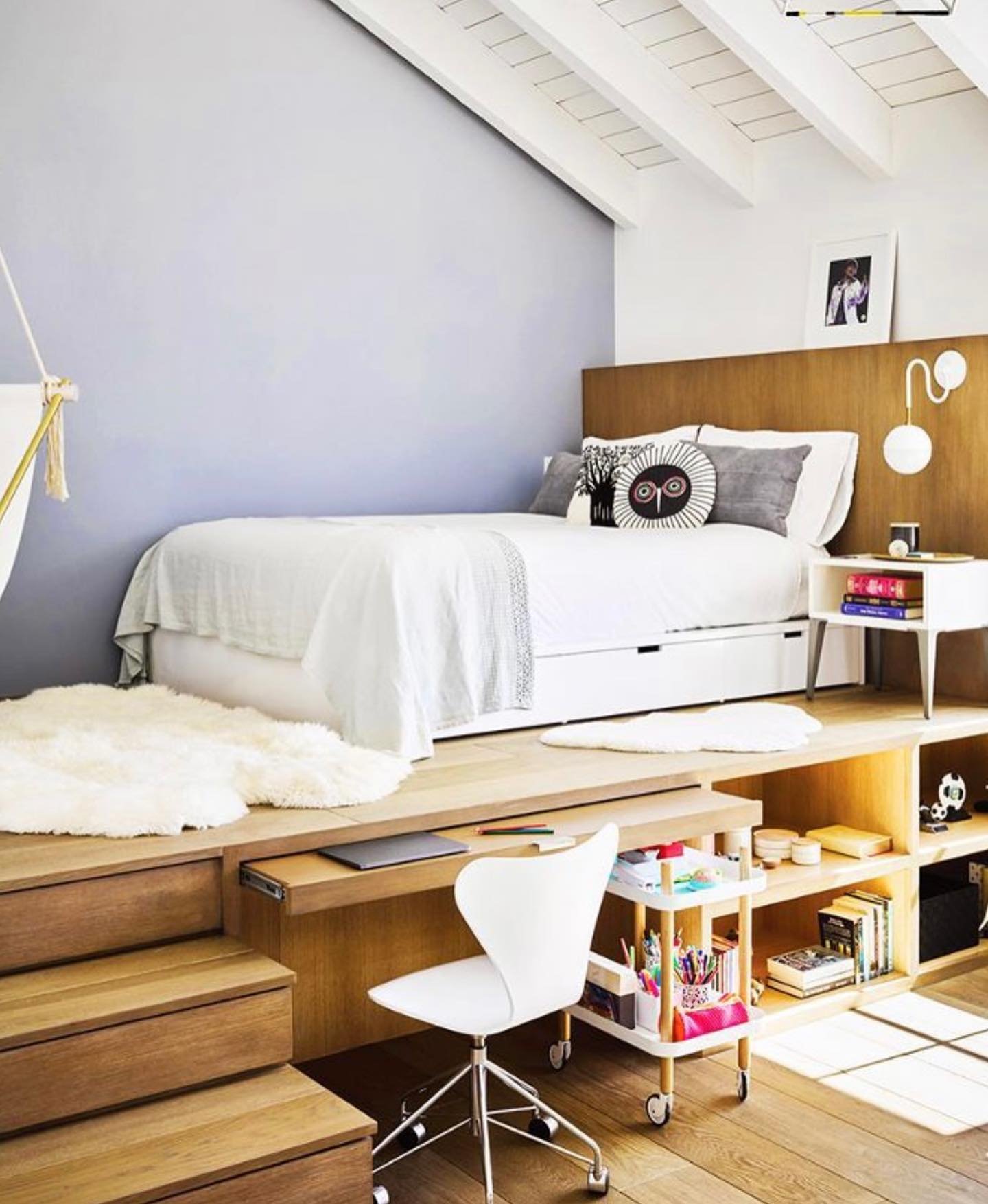 A modern teen bedroom with a raised platform bed, a built-in desk, and ample storage, showcasing a minimalist design.