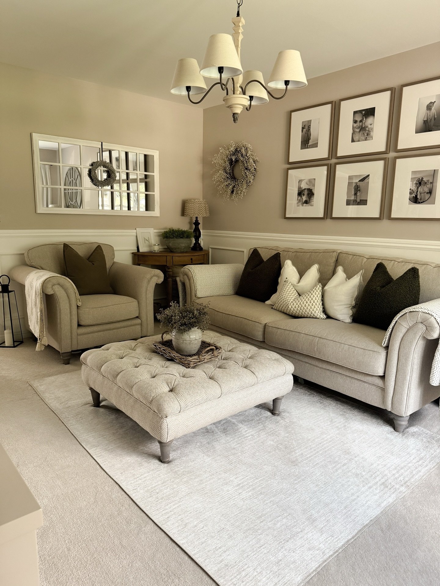 A light beige or off-white rug with a subtle, tight woven texture in a living room with a neutral-toned sofa and armchair.
