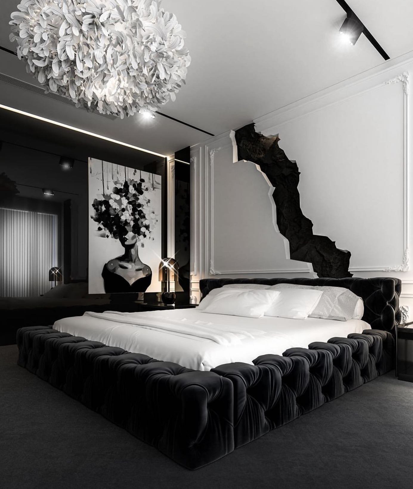 A luxurious and artistic bedroom featuring a black tufted bed, a partially "broken" white wall with ornate molding, a black accent wall, and a unique feather chandelier.