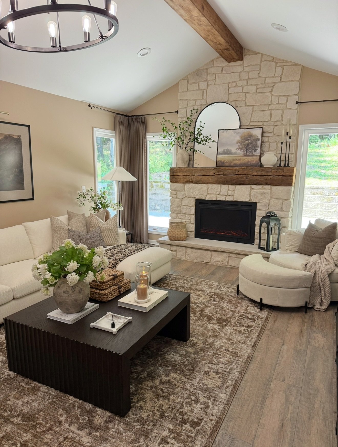 A large, distressed area rug with a vintage, ornate pattern in warm brown and beige tones on a light wood floor.