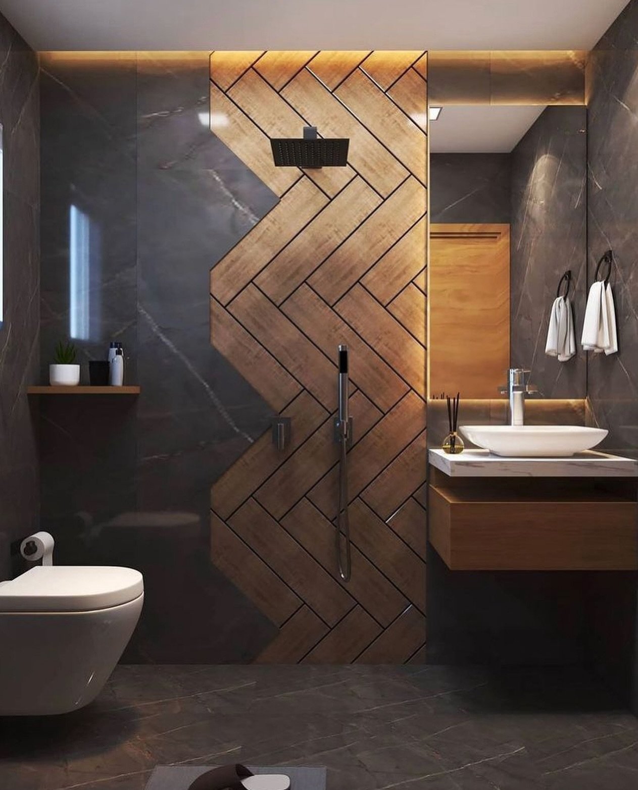 A dark and moody small bathroom with a large, zig-zag patterned wood-look tile feature wall in the shower area, and dark marble-effect tiles on the walls and floor.