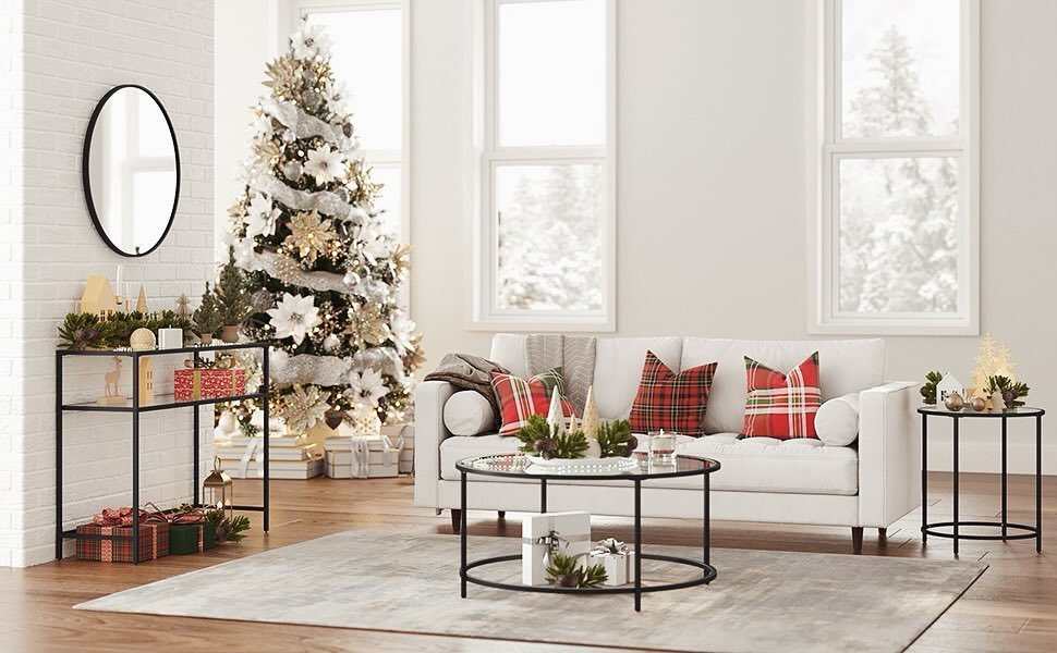Minimalist white sofa and black metal furniture accented by a large Christmas tree decorated with silver, gold, and white flowers.