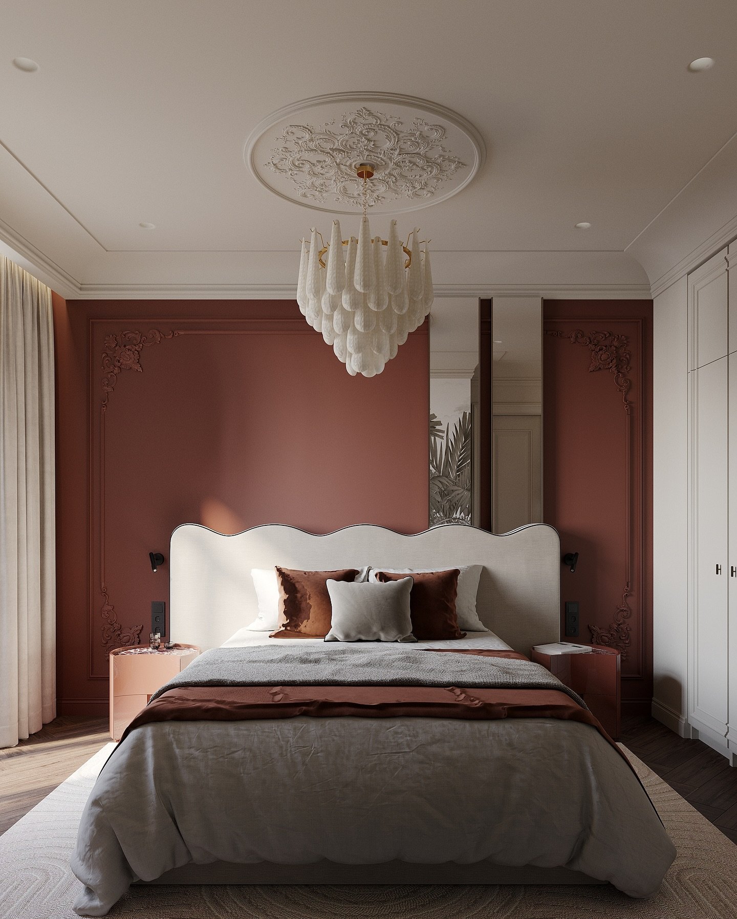 A cozy bedroom with a deep reddish-brown accent wall featuring intricate moldings, a wavy upholstered headboard, and an ornate white chandelier.