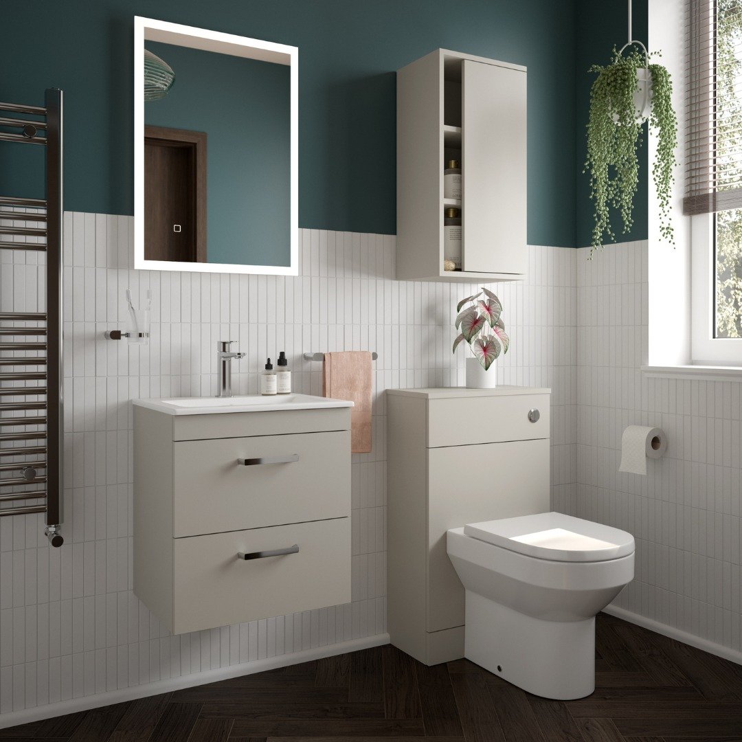 Modern bathroom with deep teal paint and white subway tile, featuring a matching pale taupe floating vanity with two drawers and a tall, wall-mounted storage cabinet.