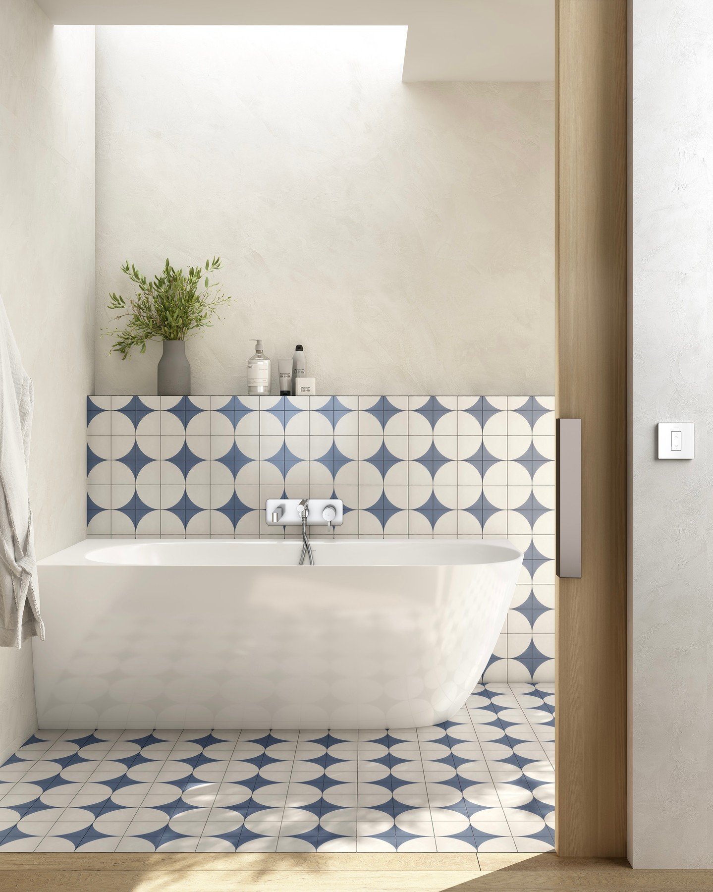 A modern, minimalist bathroom with a white freestanding bathtub and a blue and white patterned tile backsplash and floor with a repeated starburst or diamond pattern.
