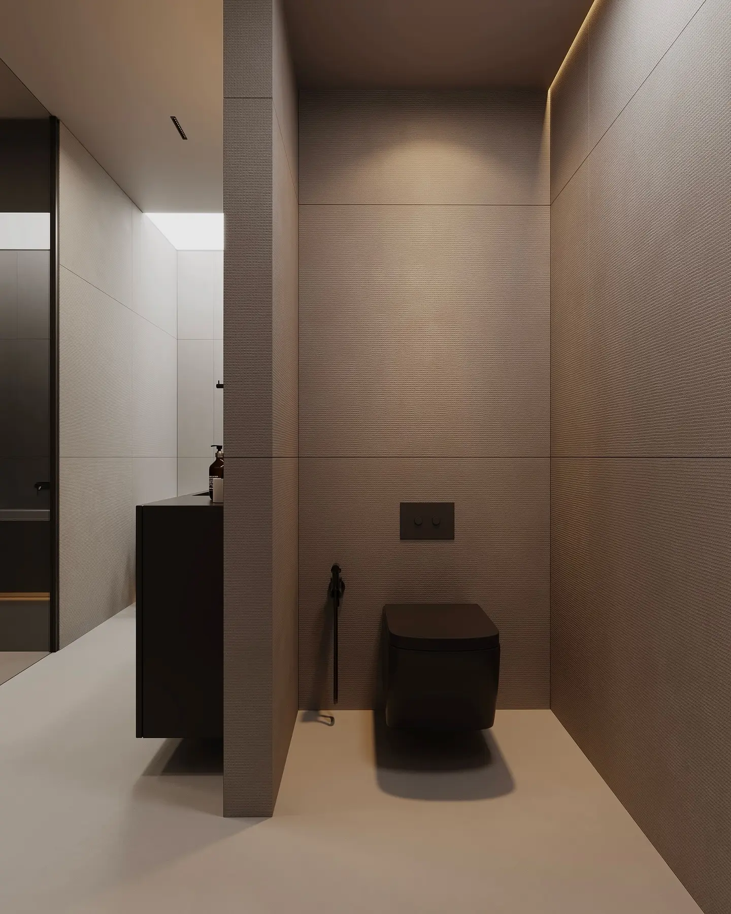 A minimalist bathroom with textured grey walls, a black floating toilet, and a subtle half-wall partition.
