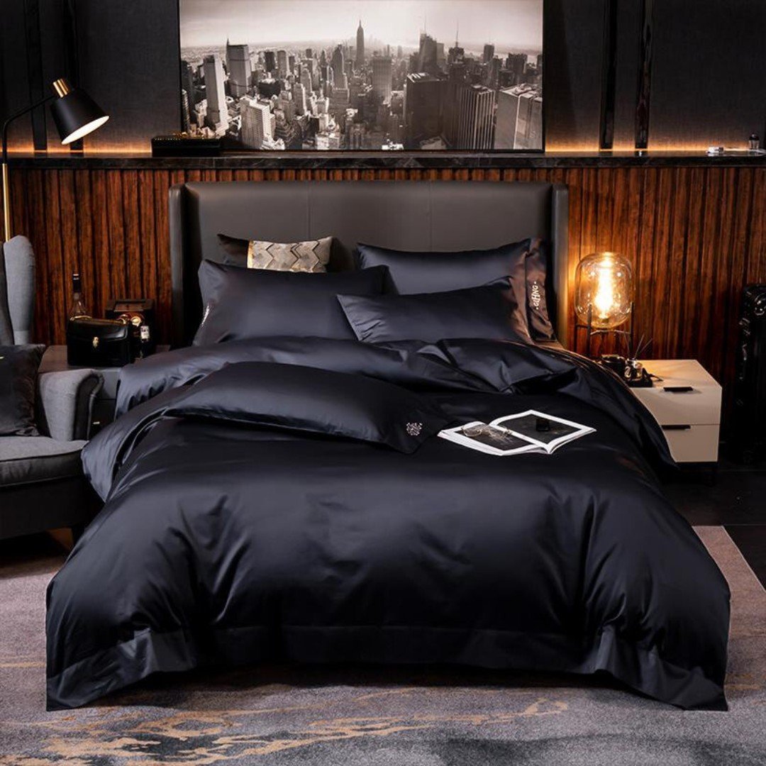 A modern bedroom with a black satin duvet, a large cityscape artwork on the wall, and warm wood paneling behind the bed.