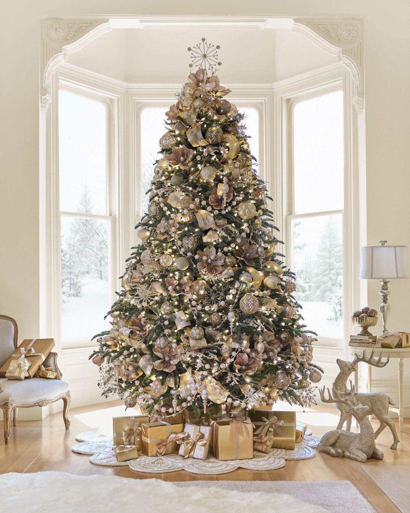A sophisticated Christmas tree decorated entirely in soft gold, blush pink, and champagne-colored ornaments and florals.