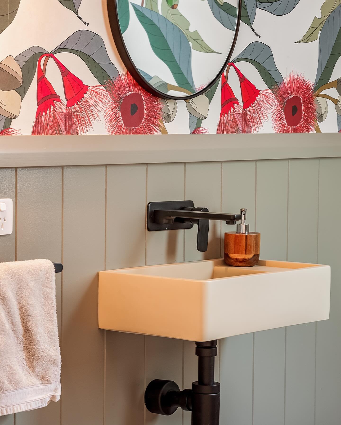 A wall-mounted, rectangular white sink in a small bathroom.