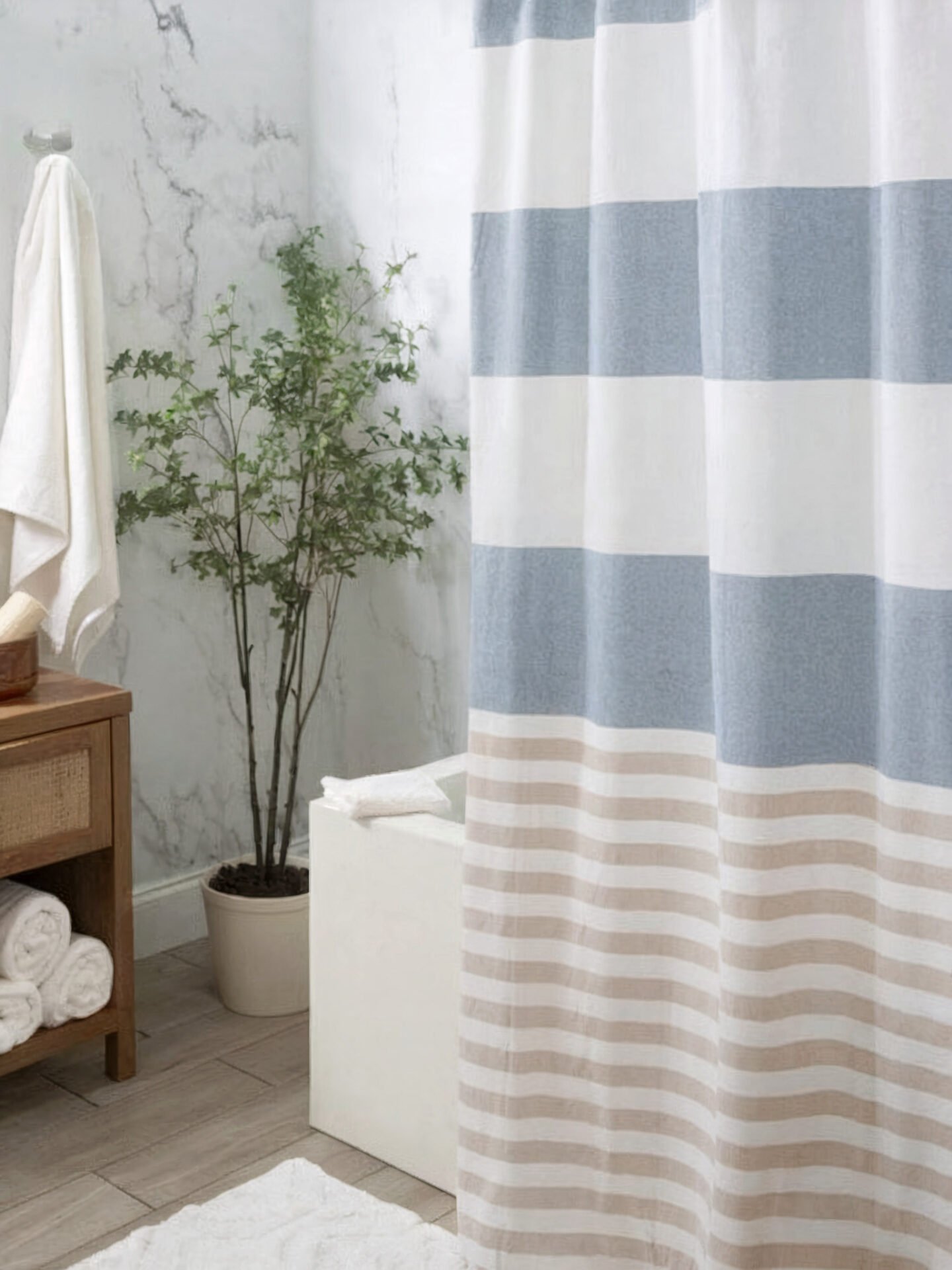 A heavy white shower curtain with wide horizontal blocks of dusty blue and thin, alternating tan and white stripes on the lower third.