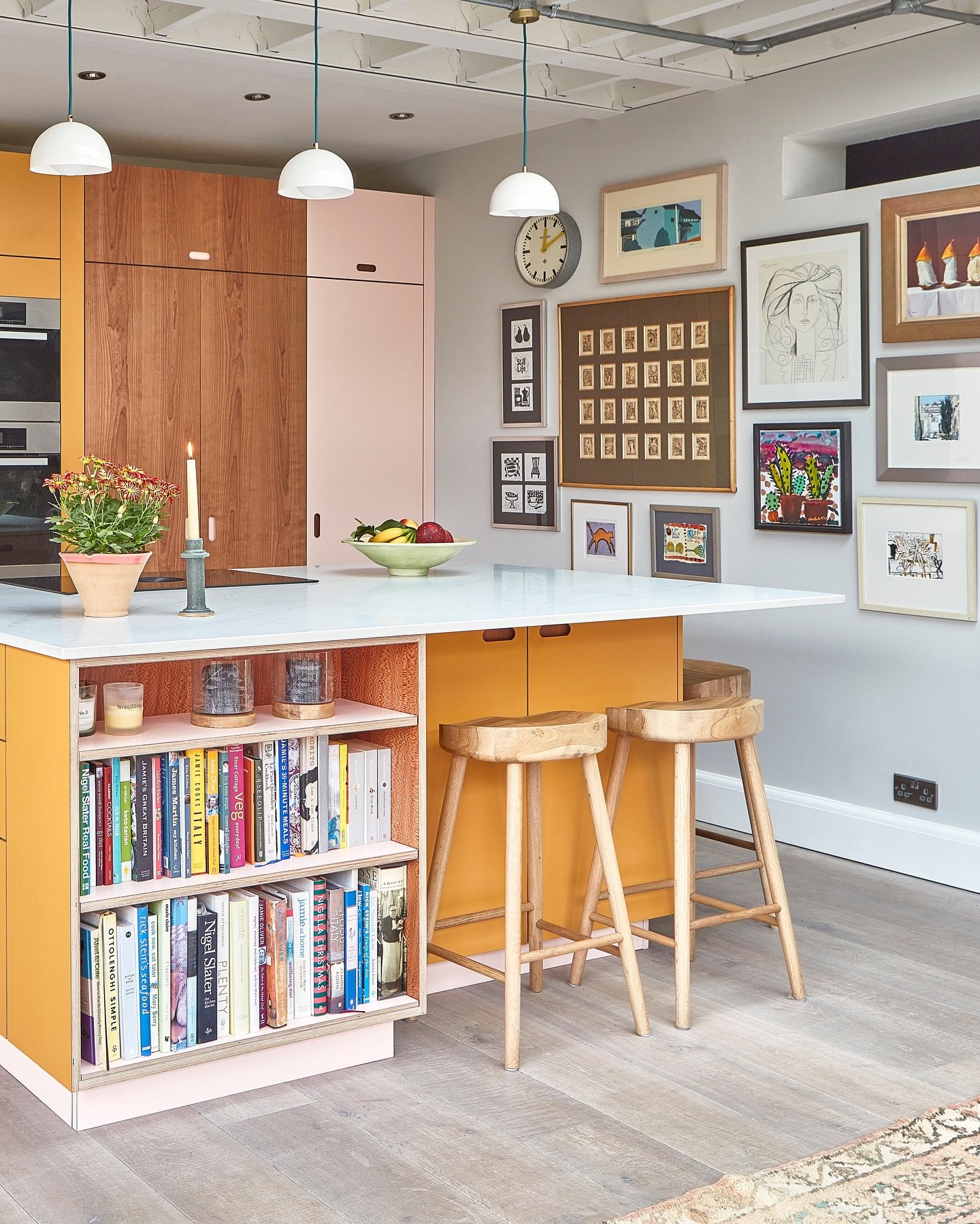 A colorful framed abstract print hanging above a light wooden kitchen counter.