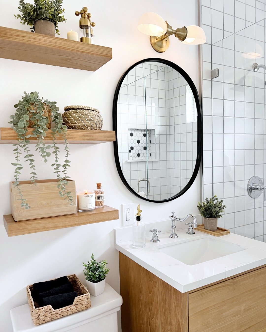 Three natural wood floating shelves on a white wall styled with plants and woven baskets.