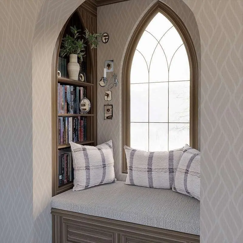 Architectural reading nook with a cushioned window seat, featuring a dramatic Gothic arched window and built-in dark wood corner shelves.