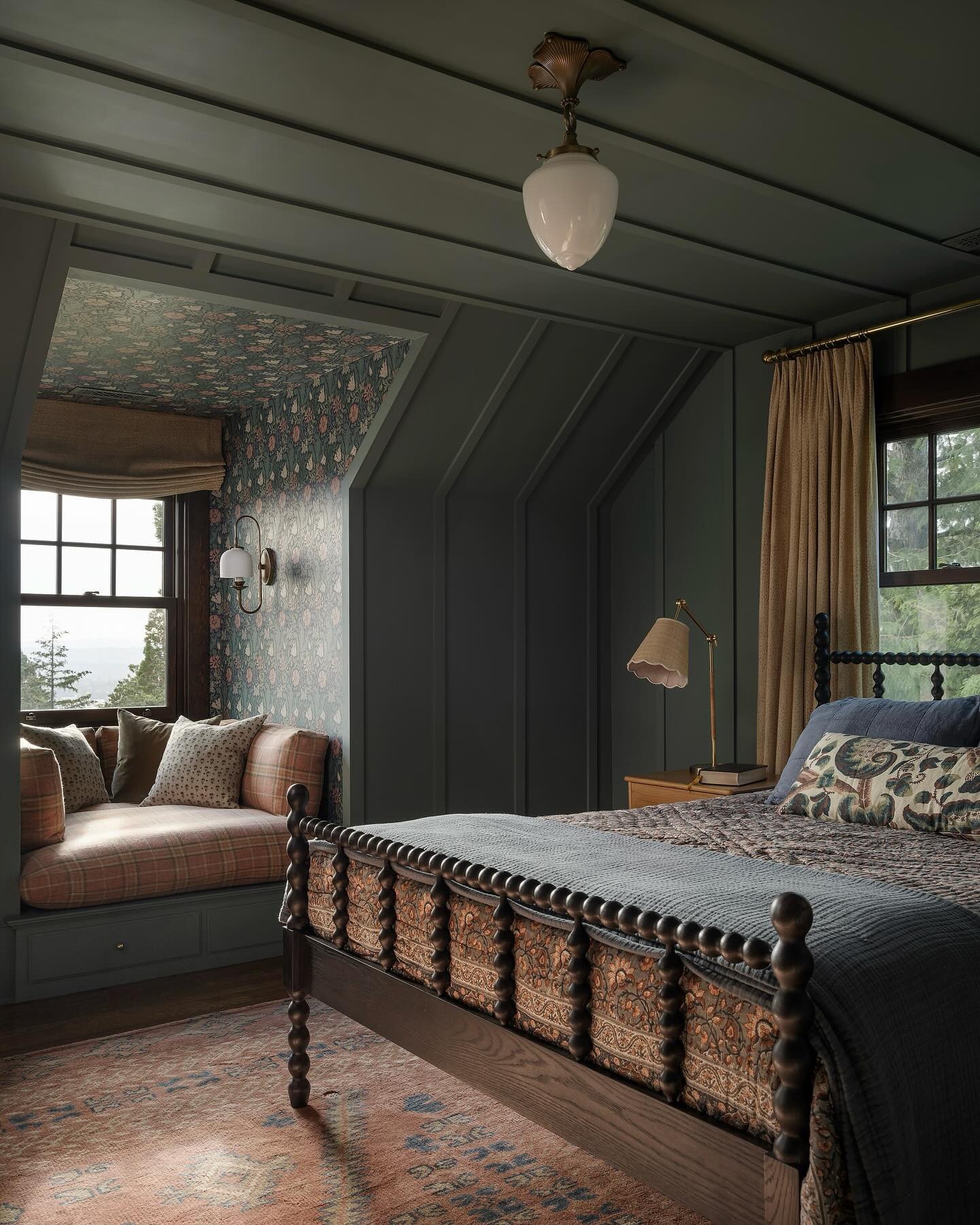 Dark olive green bedroom with textured vertical paneling, a dark wooden spool bed, and a patterned window seat.