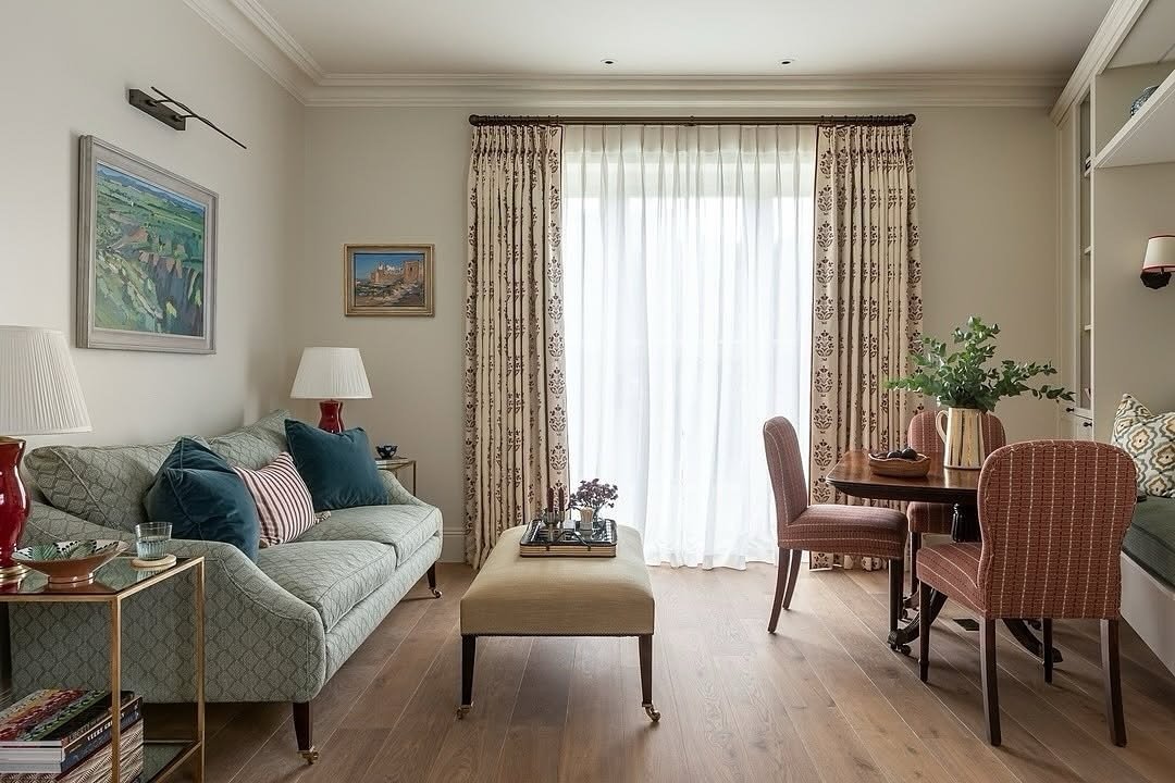 Double curtain treatment featuring sheer white drapes and side panels with a subtle burgundy pattern in a well-decorated living room.