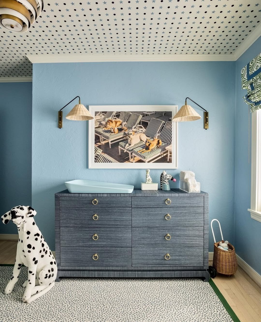 Nursery or child's bedroom featuring a wide, indigo blue double dresser with a textured finish and round brass hardware, functioning as a changing table.