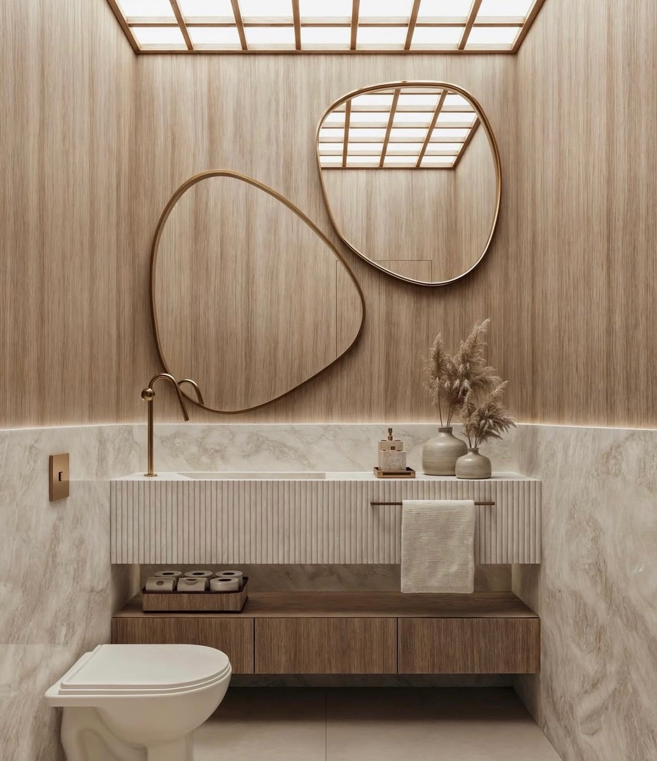 Contemporary powder room with vertical wood paneling, white marble base, fluted vanity, and organic-shaped brass mirrors under a grid skylight.