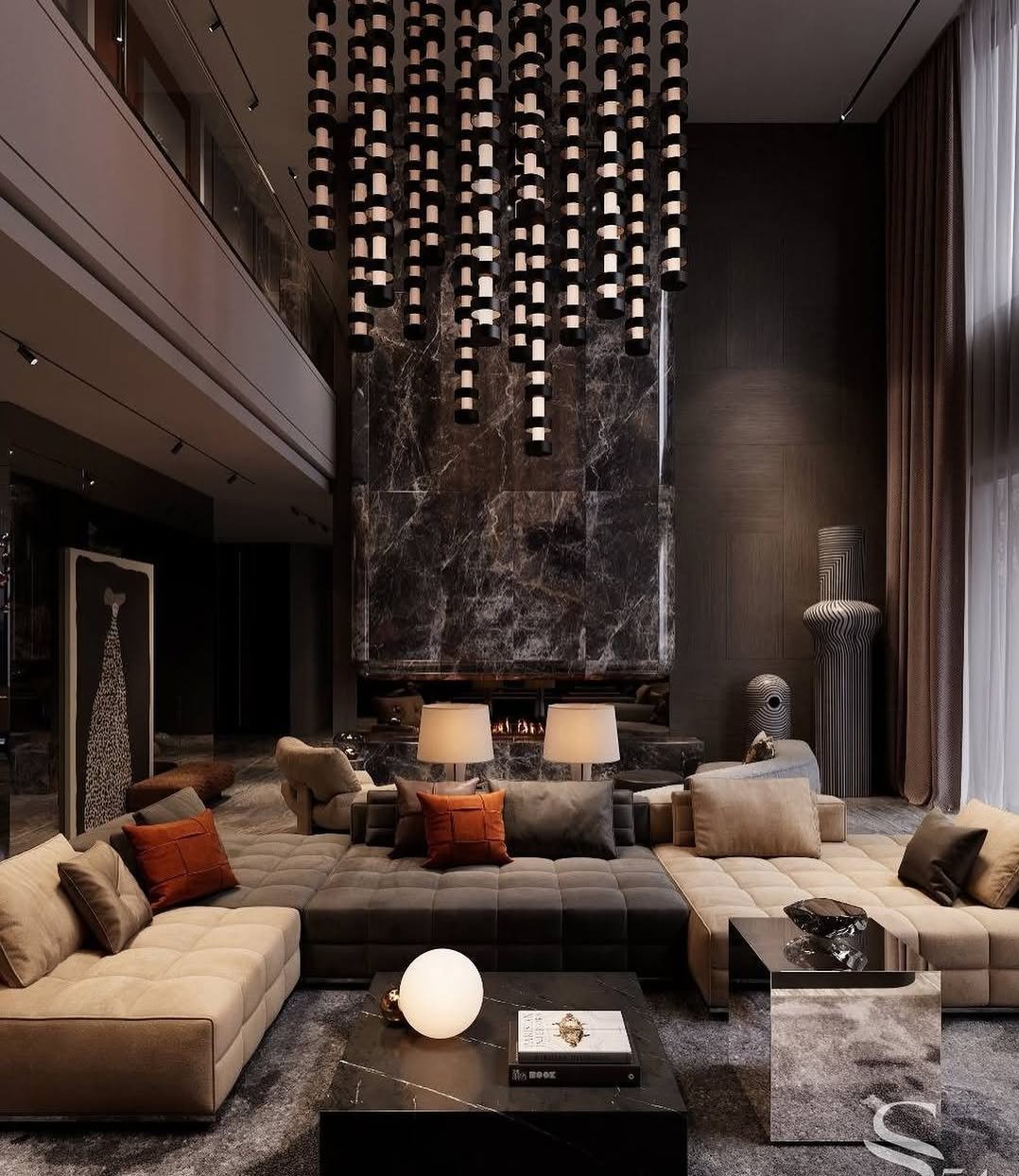 Luxurious, dark-toned living room with modular beige and charcoal sofas facing a marble fireplace, under a dramatic suspended light fixture.