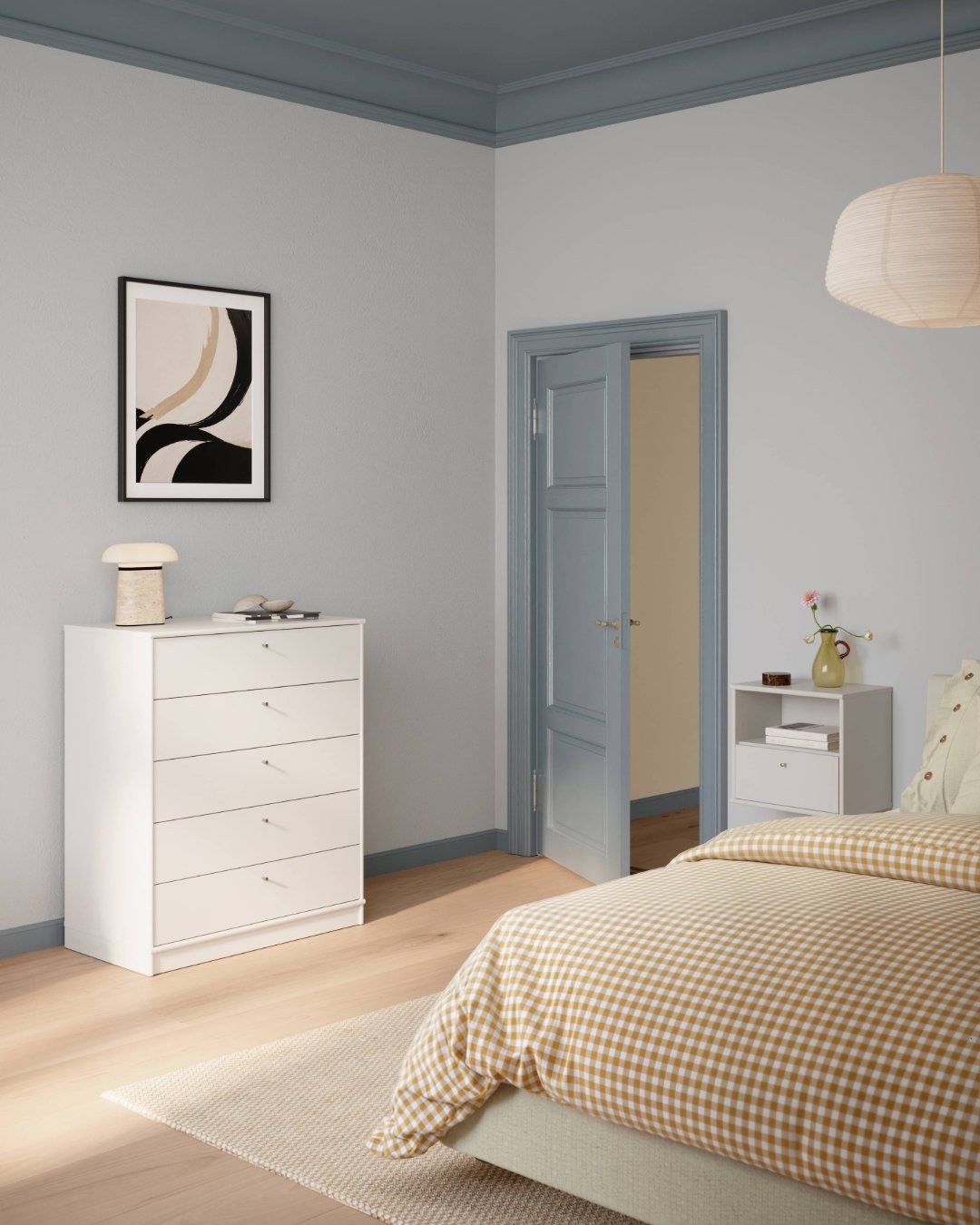 Bright bedroom with light blue walls featuring a simple, tall white chest of five drawers with small silver handles, used for vertical storage.