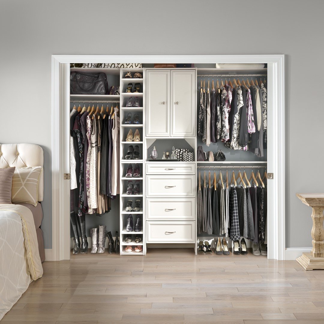 A fully organized walk-in or reach-in closet system with adjustable shelving, drawers, multiple hanging rods, and dedicated vertical shoe storage.
