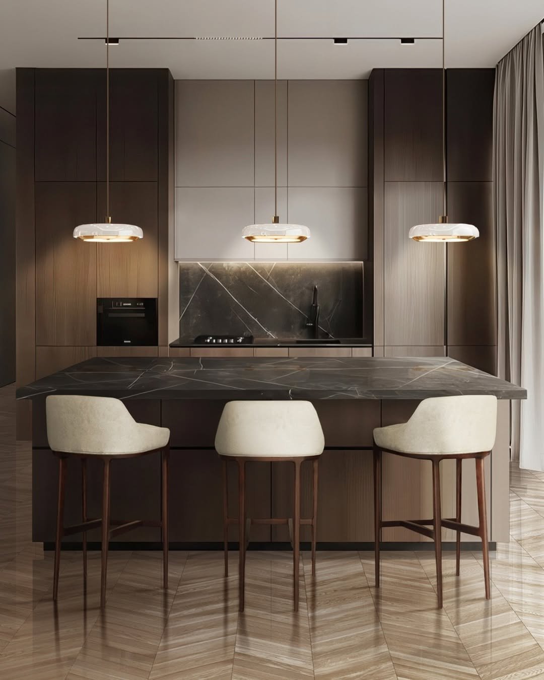 Modern kitchen featuring dark stained wood cabinetry, a black marble island and backsplash, chevron wood flooring, and three contemporary marble and brass pendant lights.