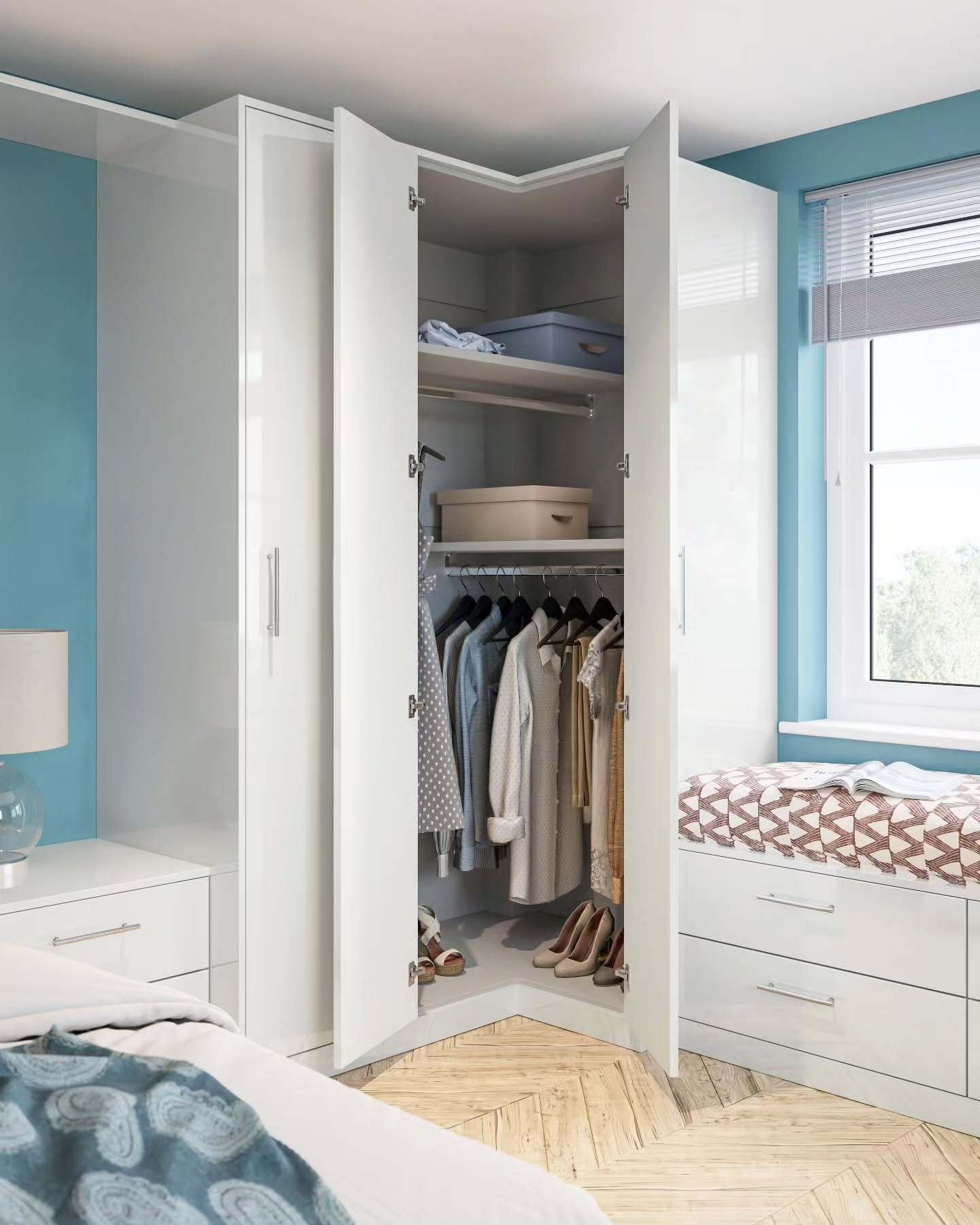 White, high-gloss fitted bedroom furniture utilizing a corner with a deep, angled wardrobe unit featuring interior hanging rods and top shelving.