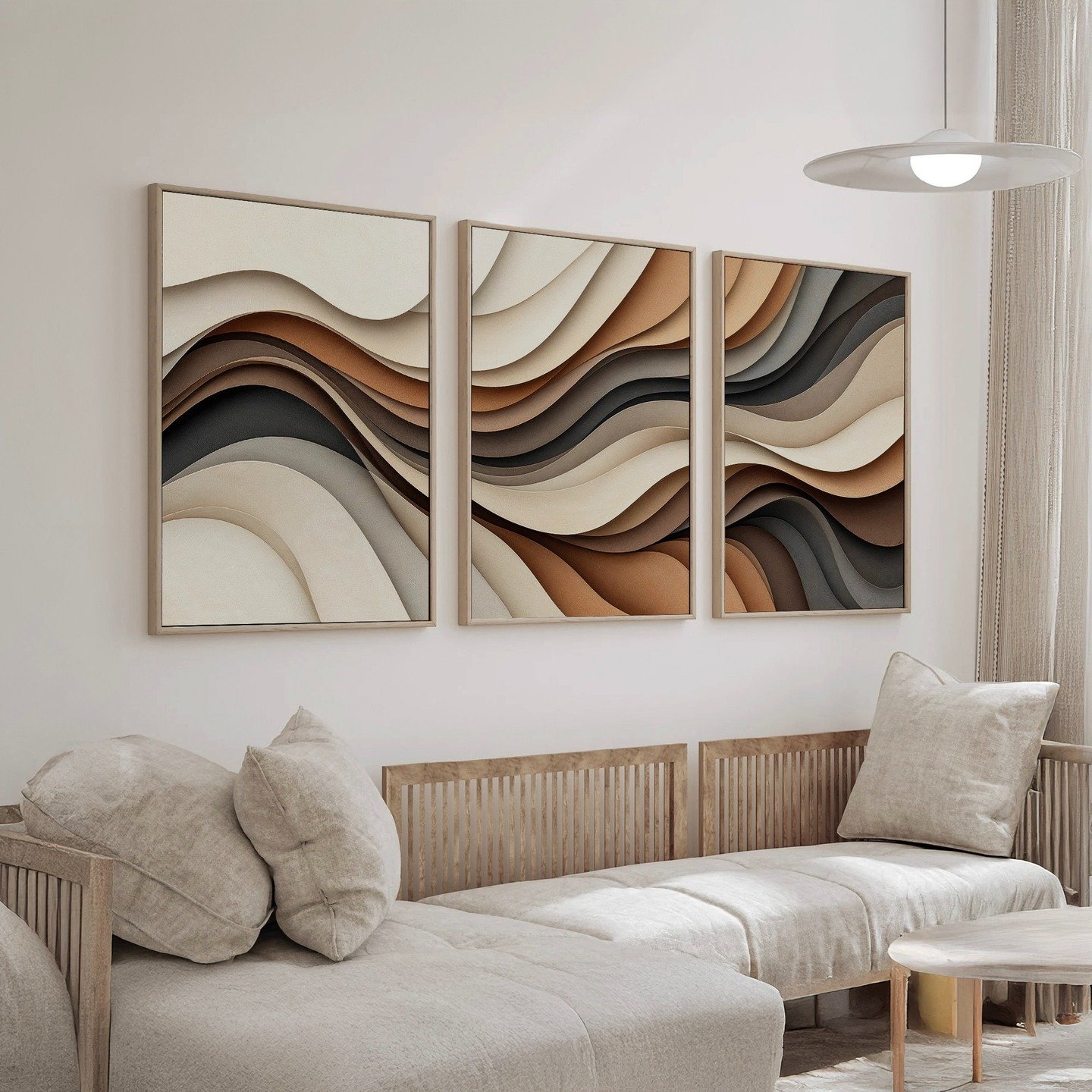 Three-panel triptych wall art with abstract waves in layers of brown, beige, and black, framed in wood and hung above a light linen sofa.