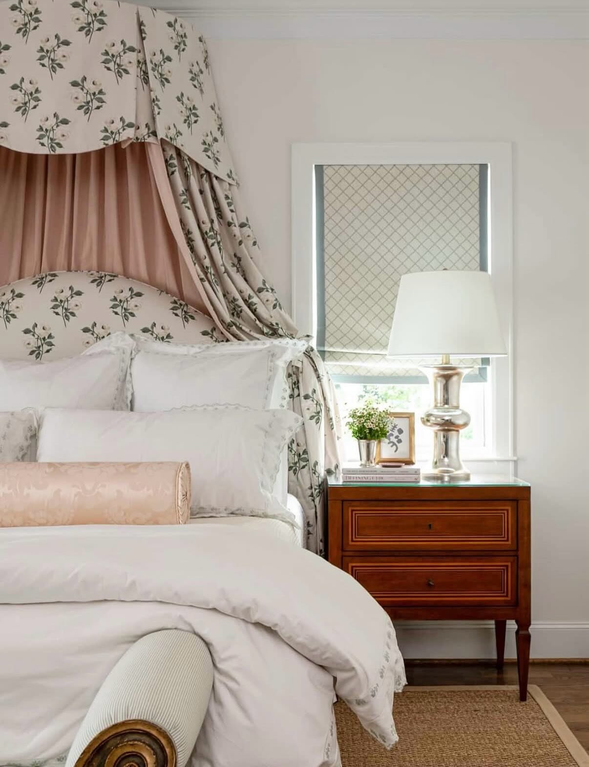 Upholstered headboard in a light pink floral print fabric, combined with a half-canopy drape made from the same fabric and a solid pink drape underneath, creating a romantic alcove.