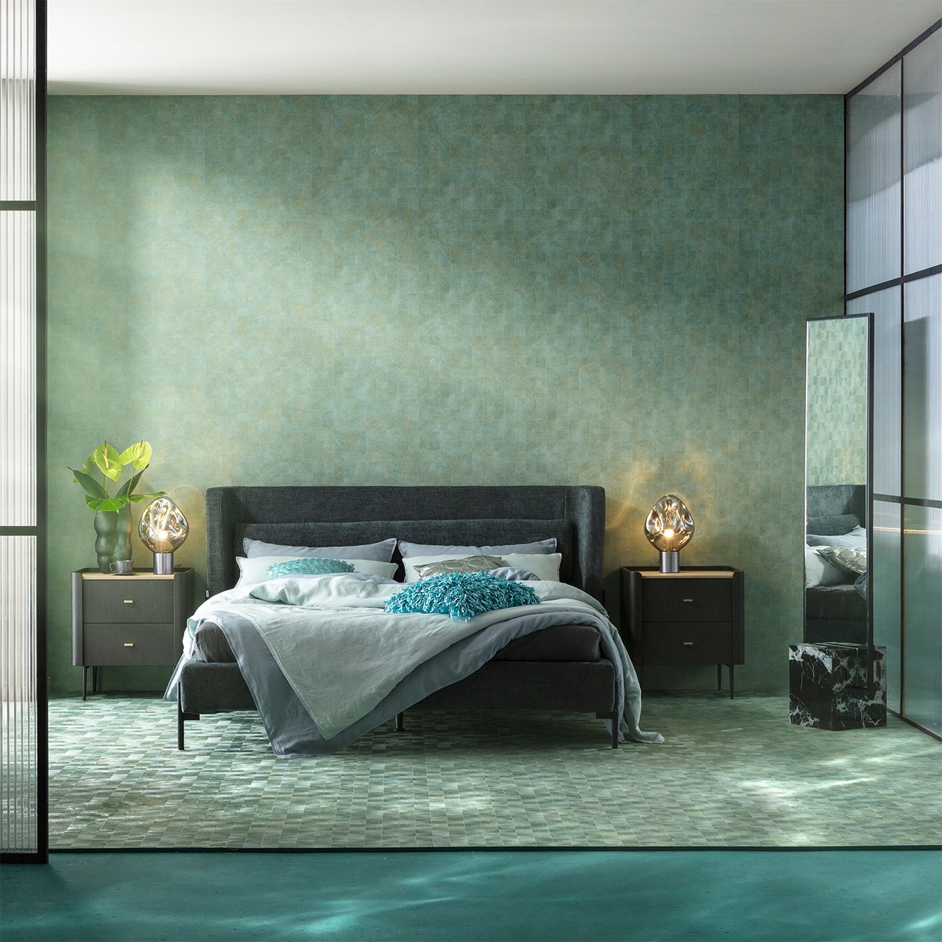 Luxurious bedroom with textured sage green walls and rug, dark grey furniture, and aqua blue accents.