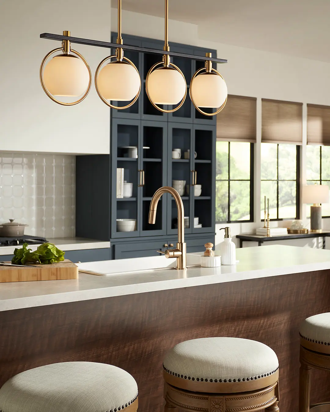 Row of small, vibrant-colored blown glass pendants in varying jewel tones over a kitchen island.