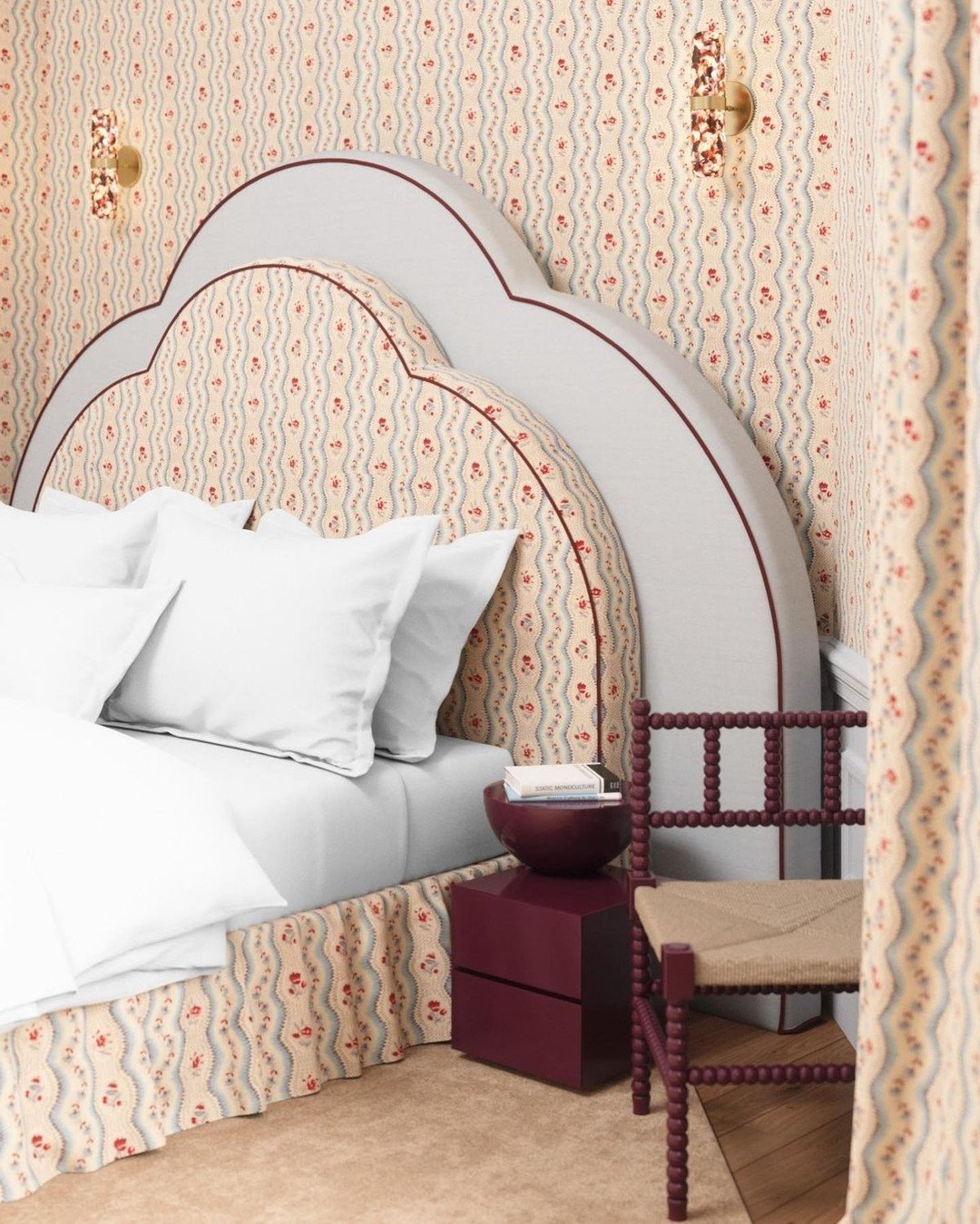 High, custom upholstered headboard with a continuous, undulating cloud-like top edge, featuring a floral and wave patterned fabric set within a solid light grey border.