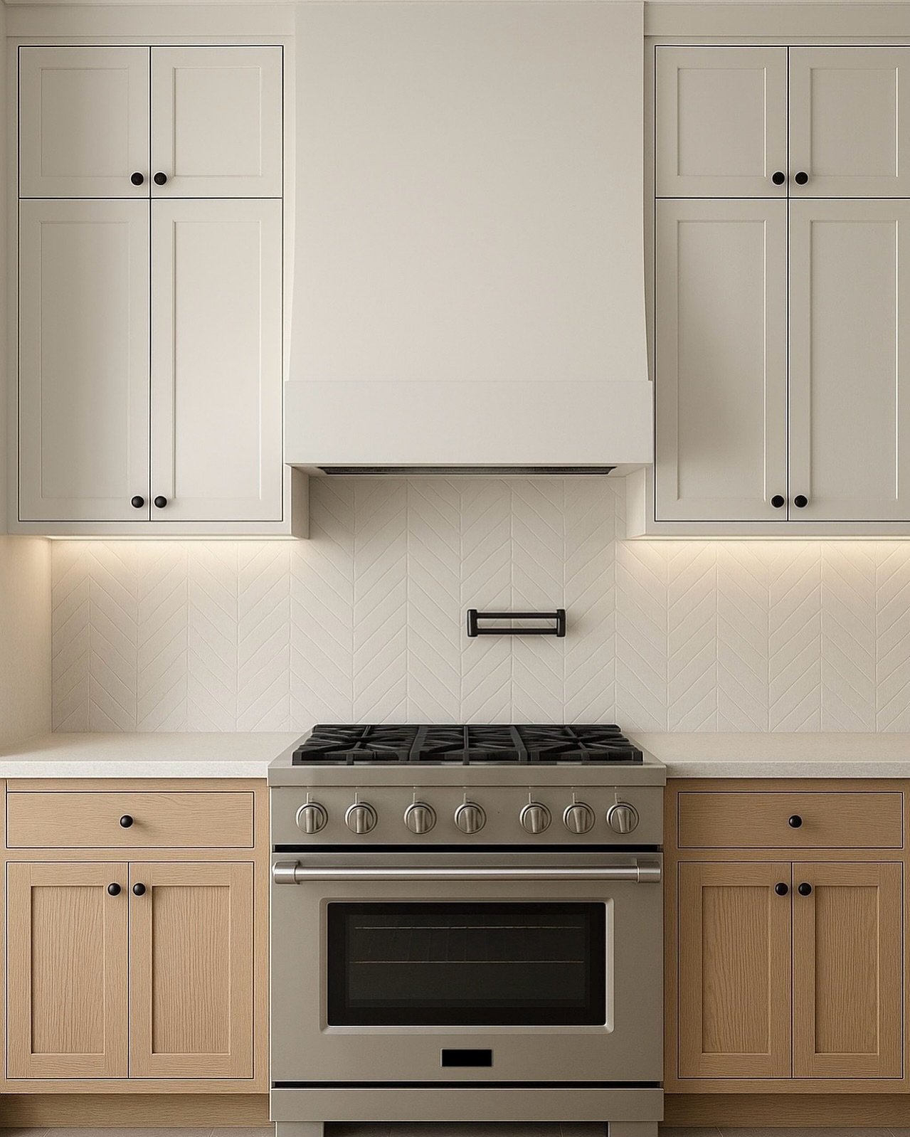Minimalist kitchen with a matte white chevron tile backsplash, a stainless steel range, and two-tone cabinetry featuring natural wood base cabinets and creamy upper cabinets with black knobs.