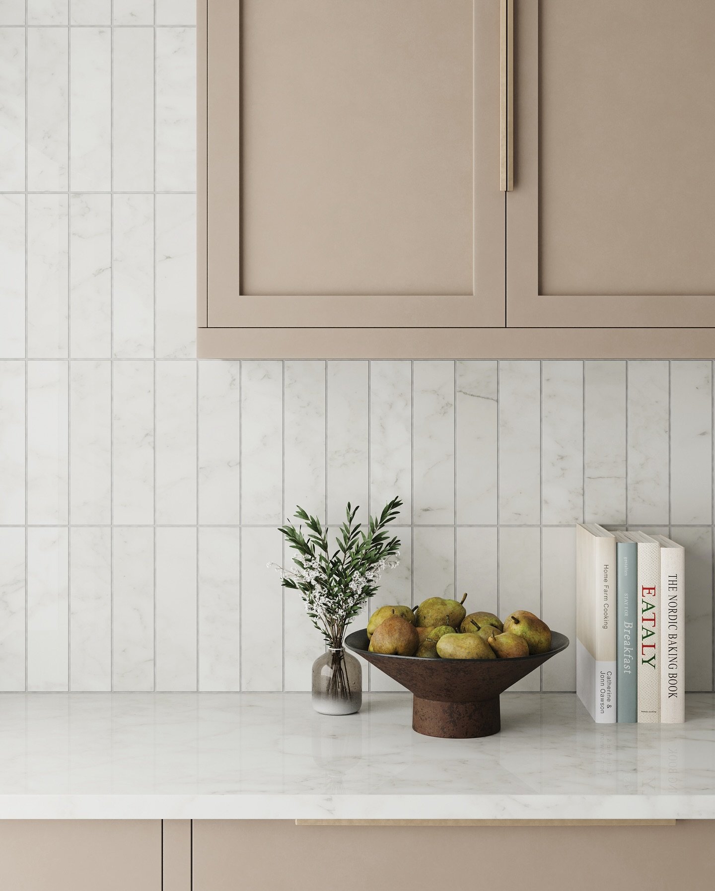 Kitchen backsplash featuring slender, vertically stacked white marble tiles with soft gray veining, complementing taupe cabinets and a marble countertop.