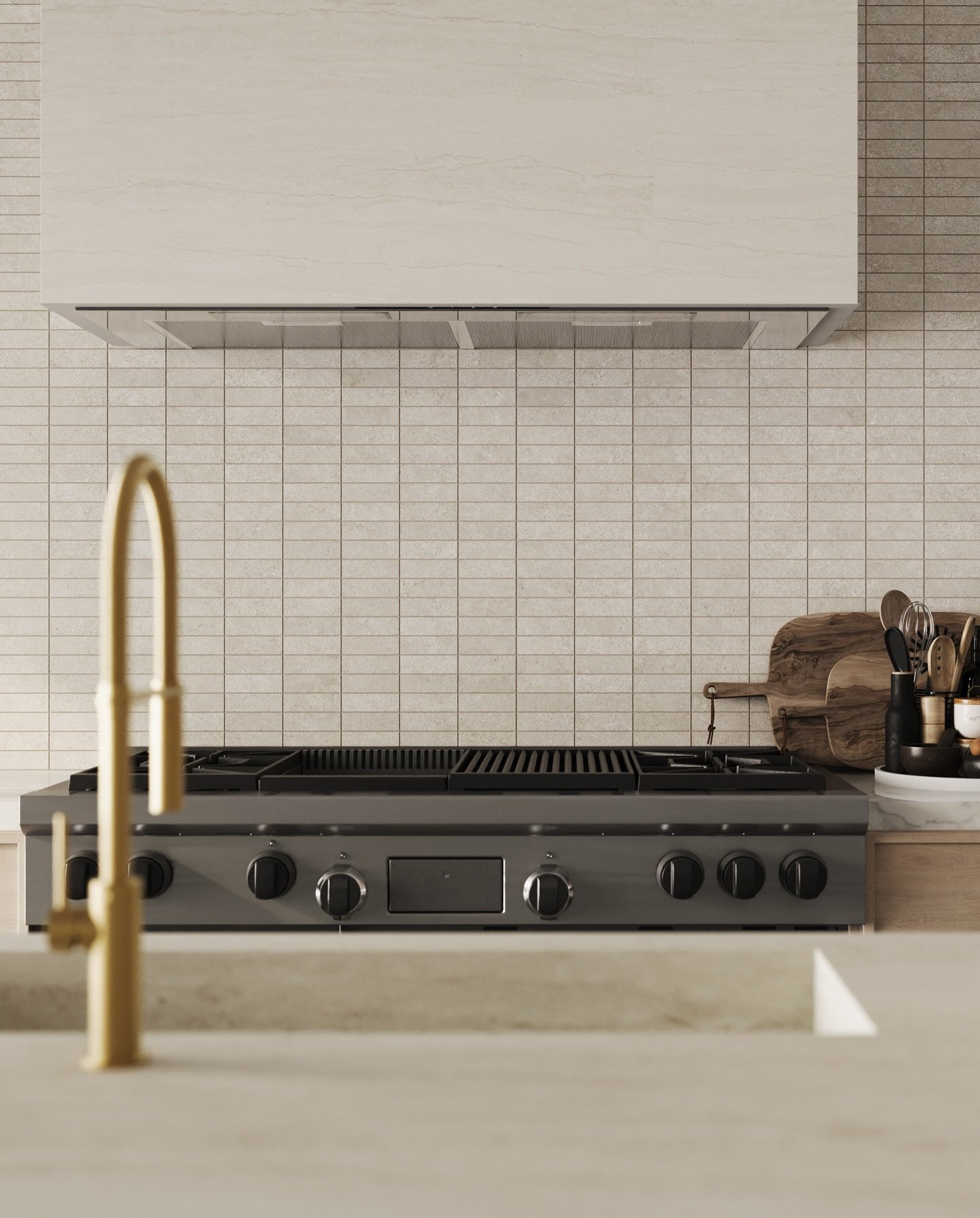 Kitchen backsplash composed of thin, rectangular subway tiles in a light sandy beige color with subtle variation, set above a professional gas range.