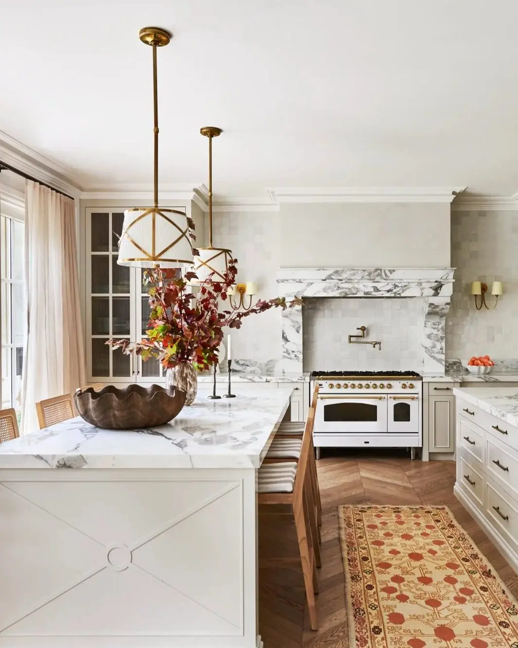 Long, horizontal linear suspension light with multiple small glass shades over a kitchen island.