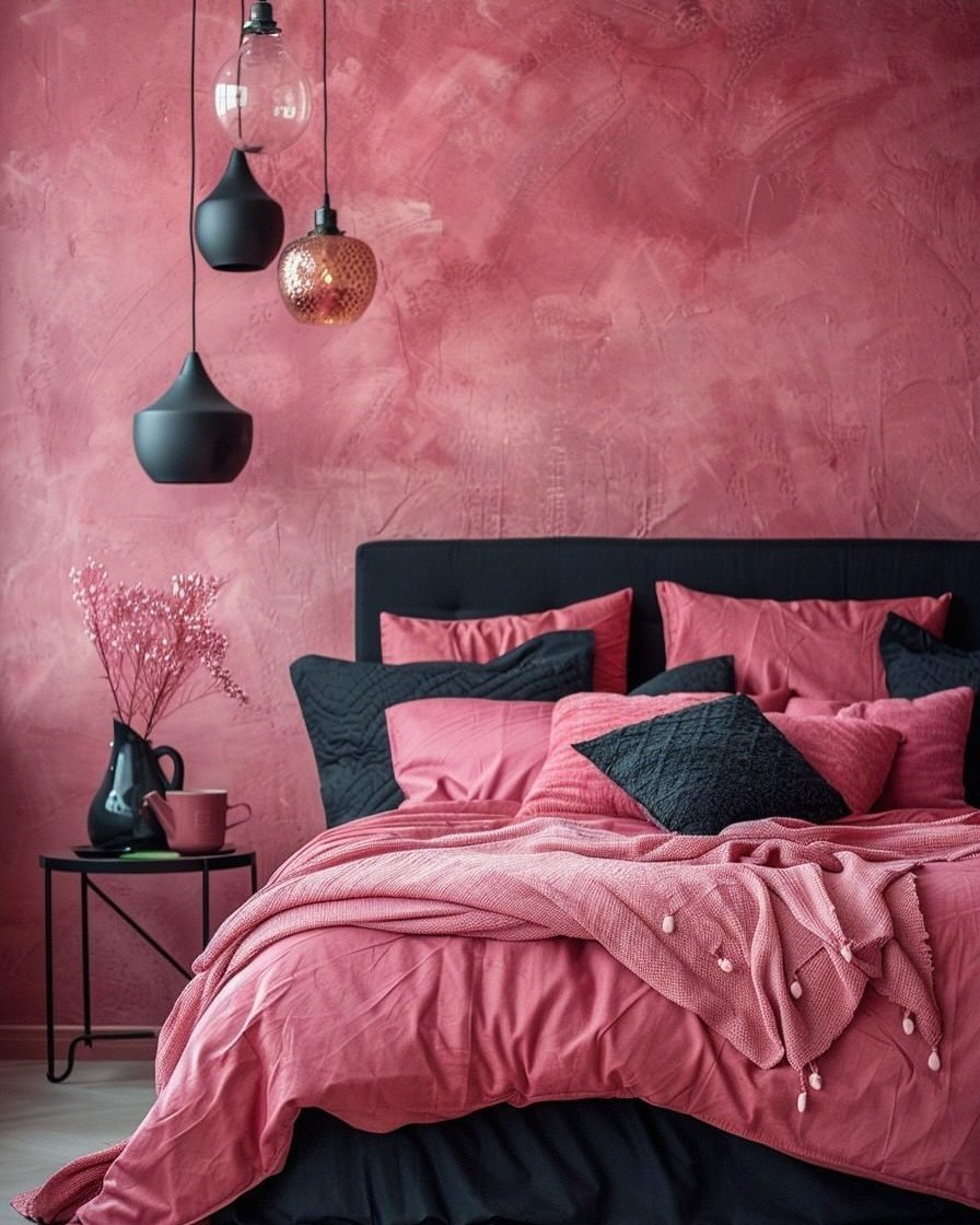 Bedroom featuring a textured, distressed pink wall, dark gray and pink bedding, and hanging black pendant lights.